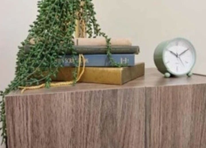 Clock and books on a wooden shelf at Heathers Healing Haven in Lakeville, Massachusetts, US.