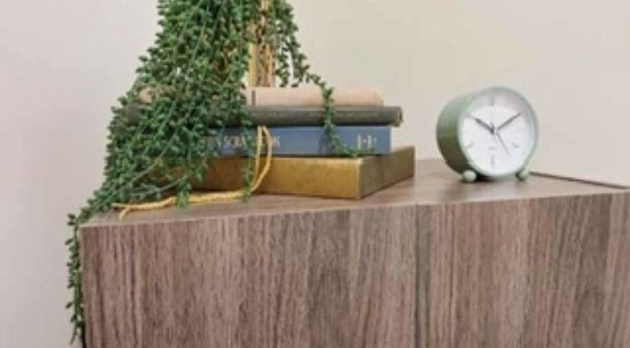 Clock and books on a wooden shelf at Heathers Healing Haven in Lakeville, Massachusetts, US.