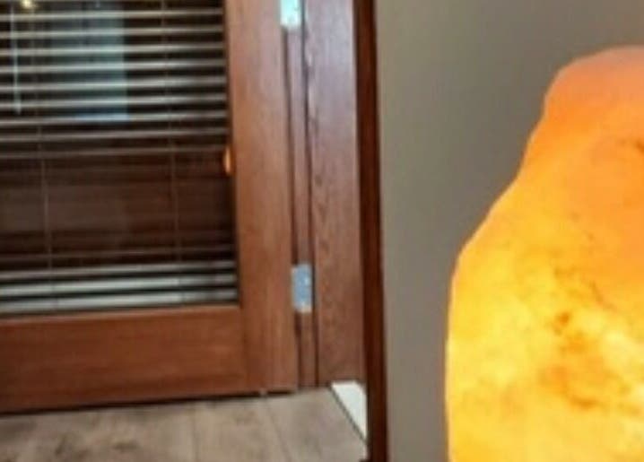 Warm salt lamp by wooden door at Heather's Healing Haven, Lakeville, Massachusetts, US.