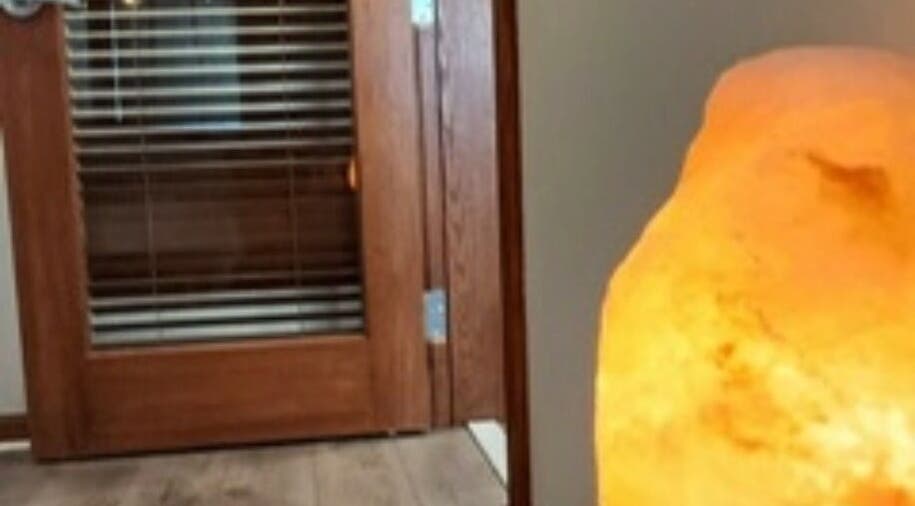 Warm salt lamp by wooden door at Heather's Healing Haven, Lakeville, Massachusetts, US.