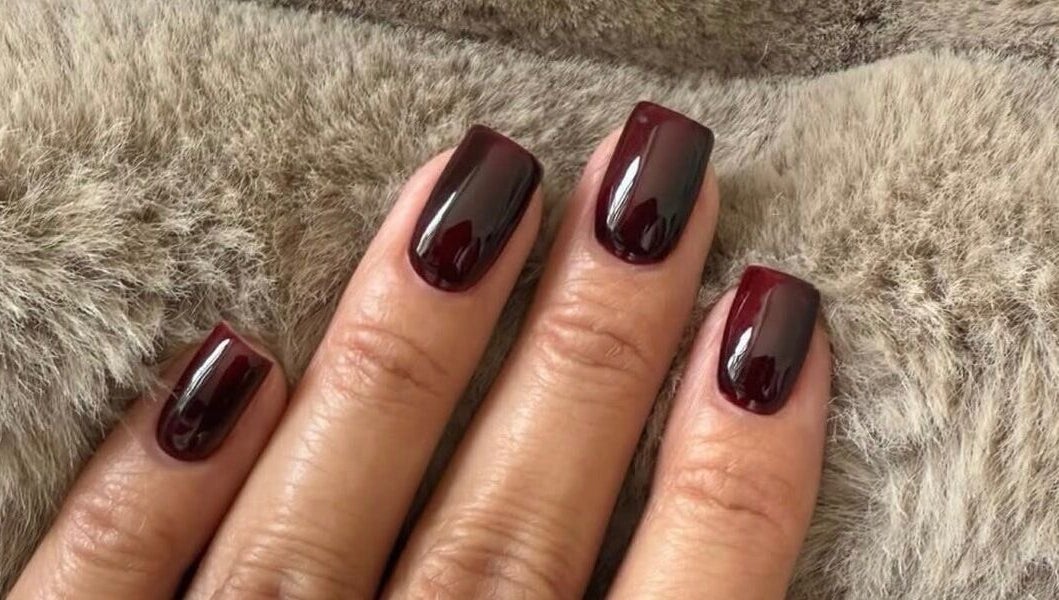 Elegant dark plum manicure by Biab By Amber in Watford, England, GB. Perfect finish on soft background.