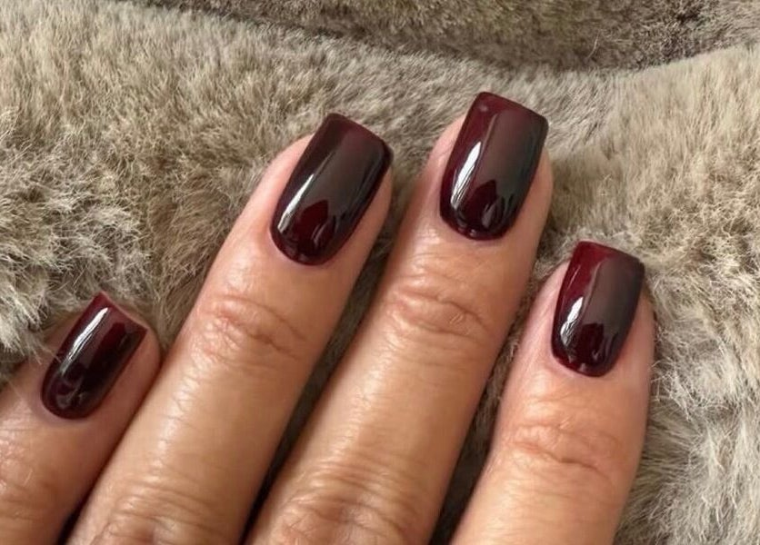 Elegant dark plum manicure by Biab By Amber in Watford, England, GB. Perfect finish on soft background.