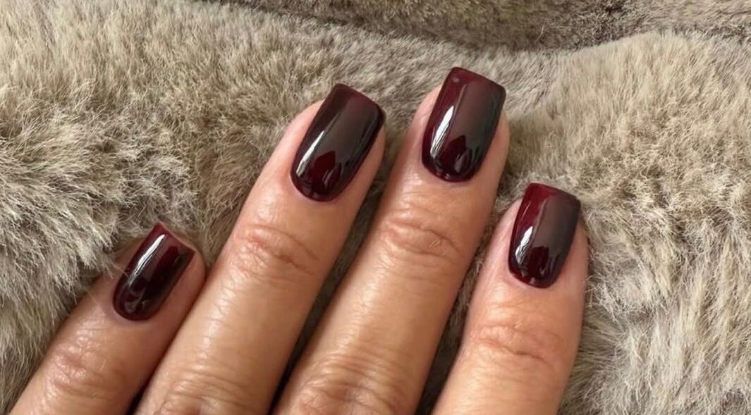 Elegant dark plum manicure by Biab By Amber in Watford, England, GB. Perfect finish on soft background.