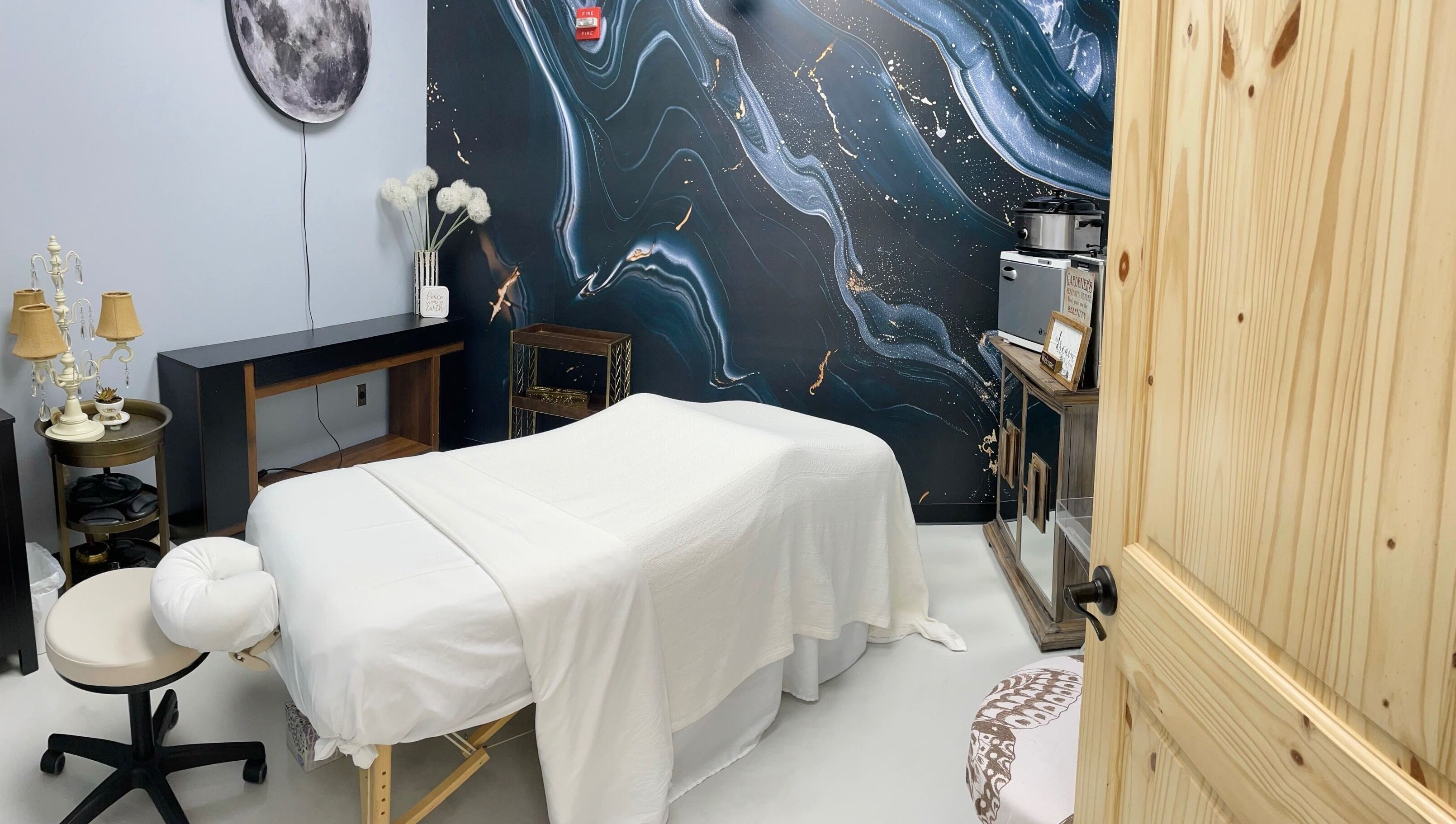 Serene massage room at AUM Body Bliss LLC, Saint Albans City, Vermont, US with celestial-themed decor.