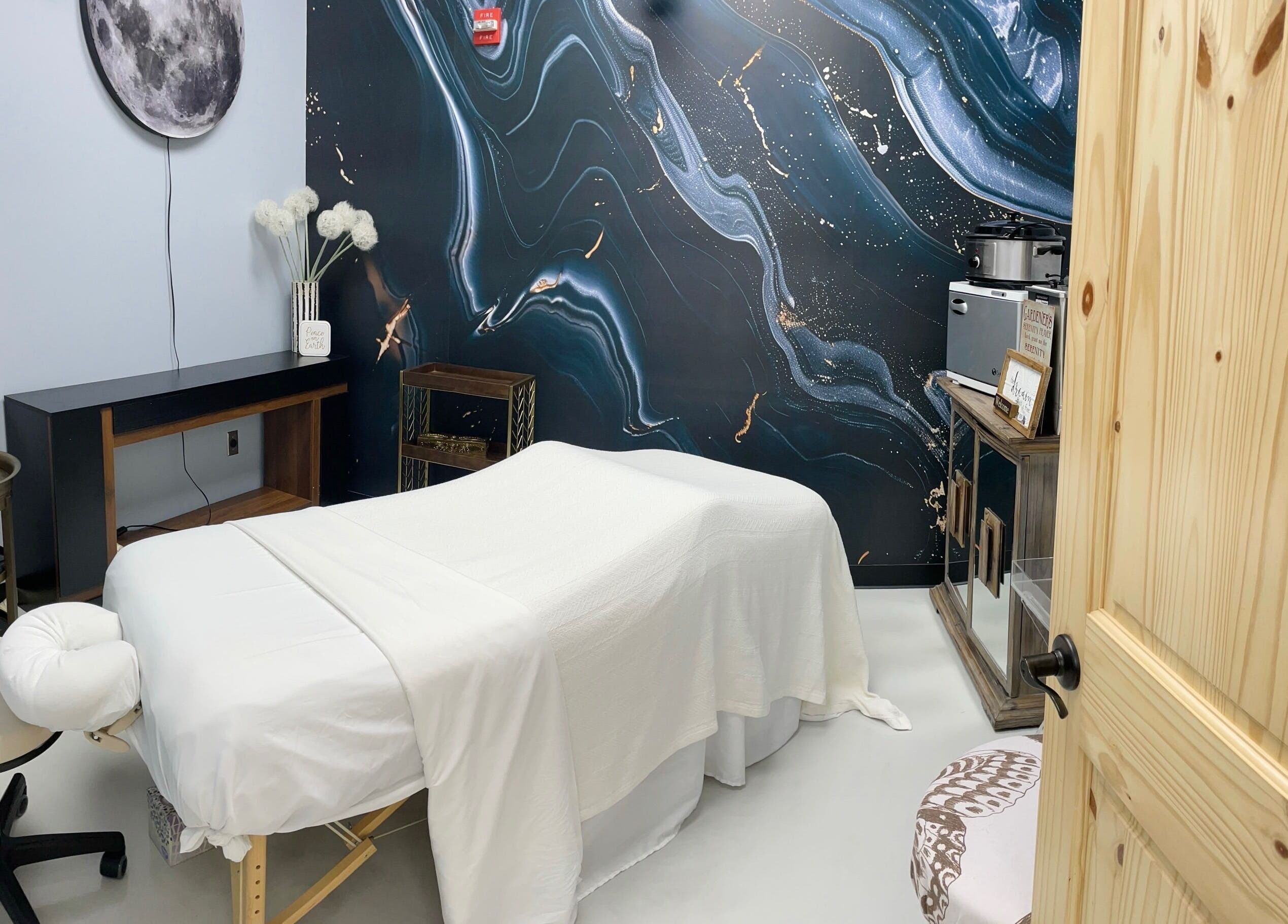 Serene massage room at AUM Body Bliss LLC, Saint Albans City, Vermont, US with celestial-themed decor.