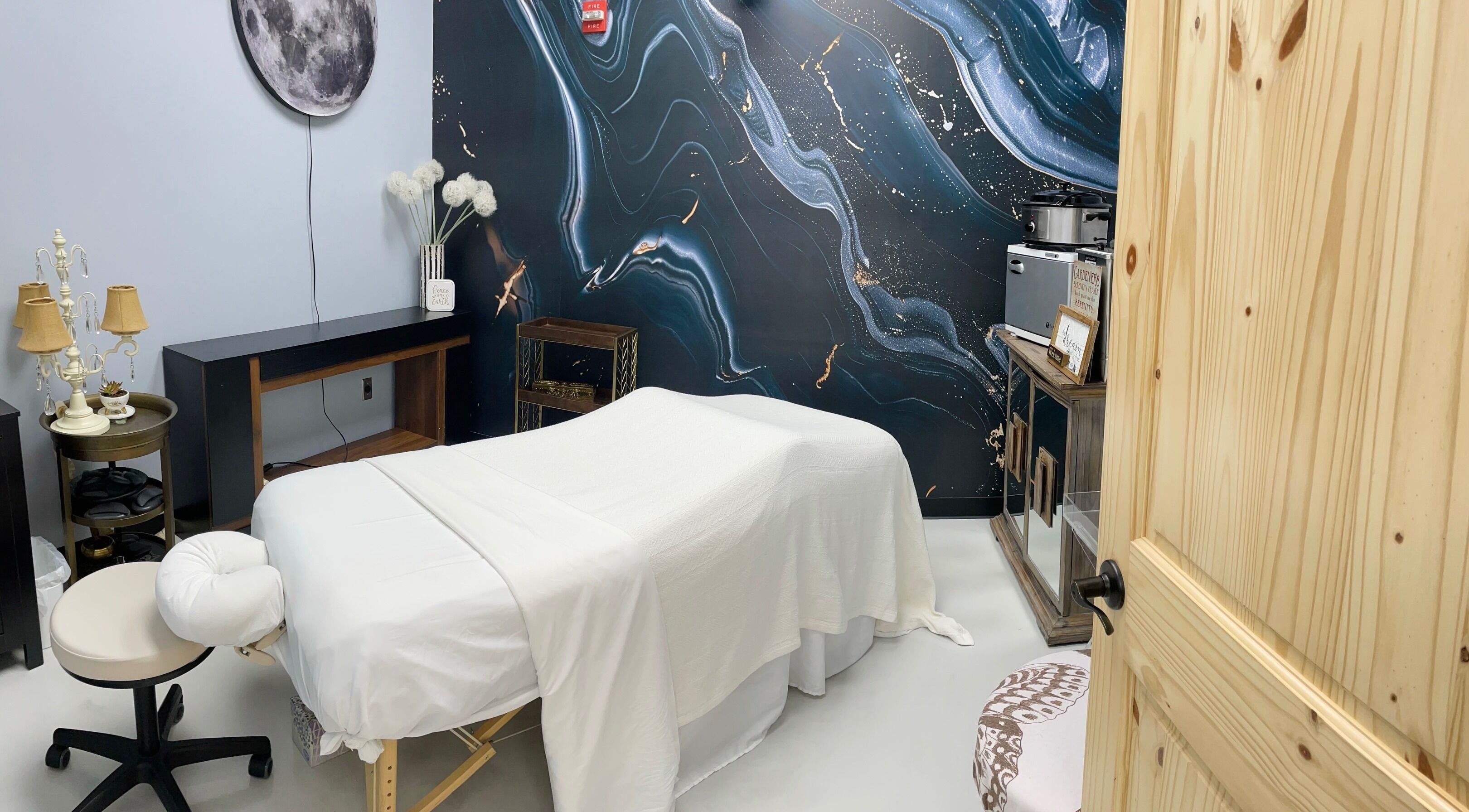 Serene massage room at AUM Body Bliss LLC, Saint Albans City, Vermont, US with celestial-themed decor.