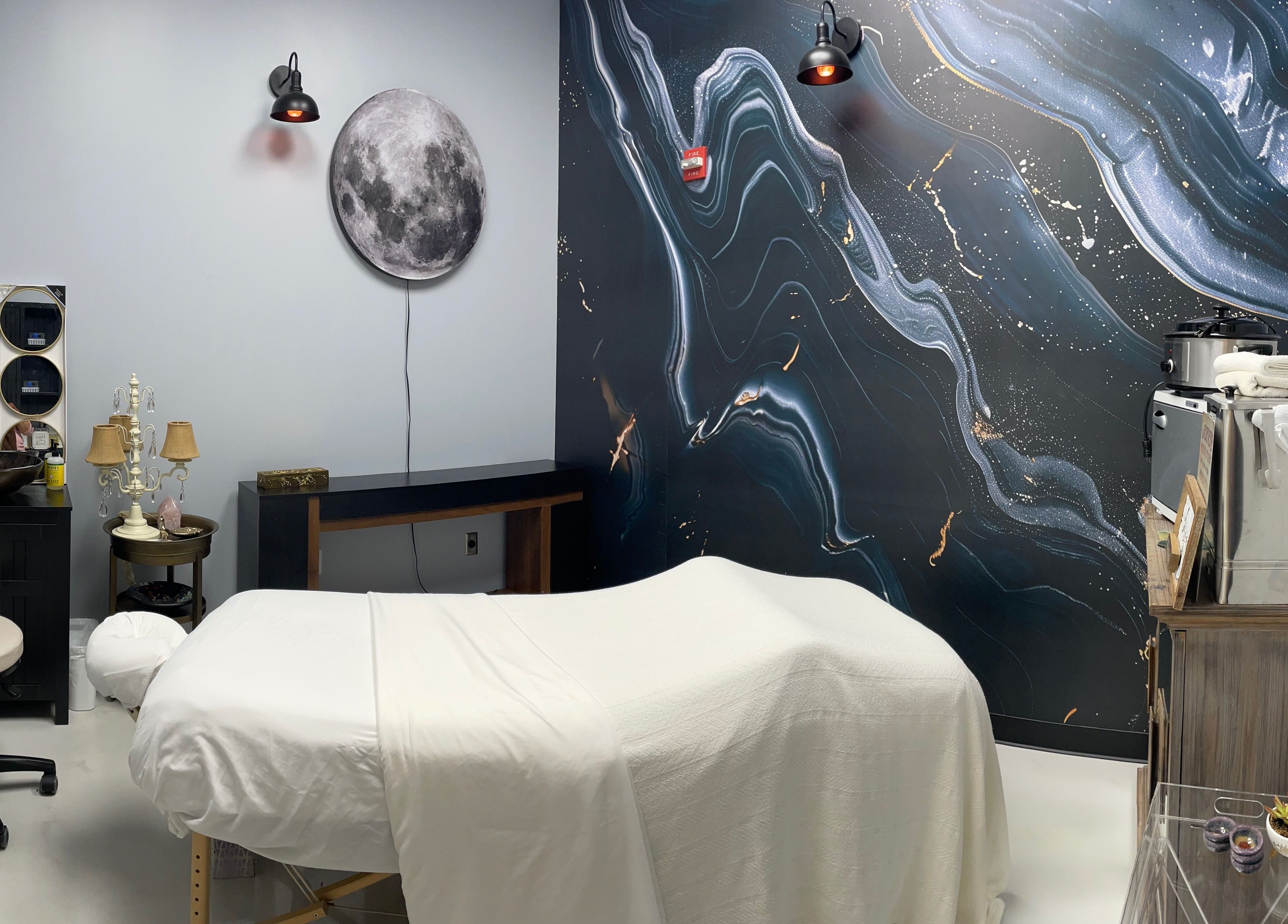 Relaxing therapy room at AUM Body Bliss LLC, Saint Albans City, Vermont, US, featuring cosmic wall art.