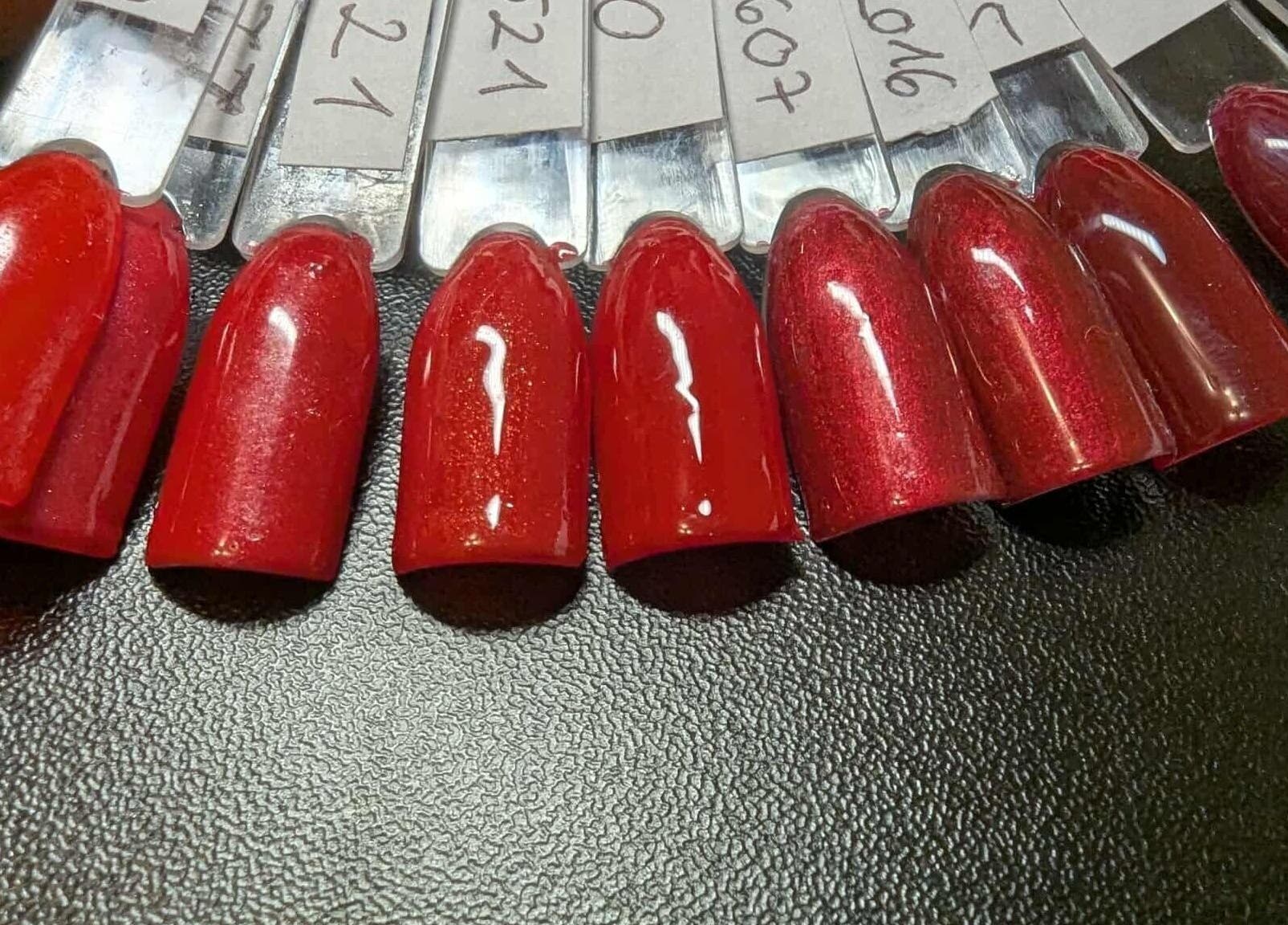 Vibrant red nail polish shades at Agi Nails, Bulwark, Wales, GB showcasing bold beauty options.