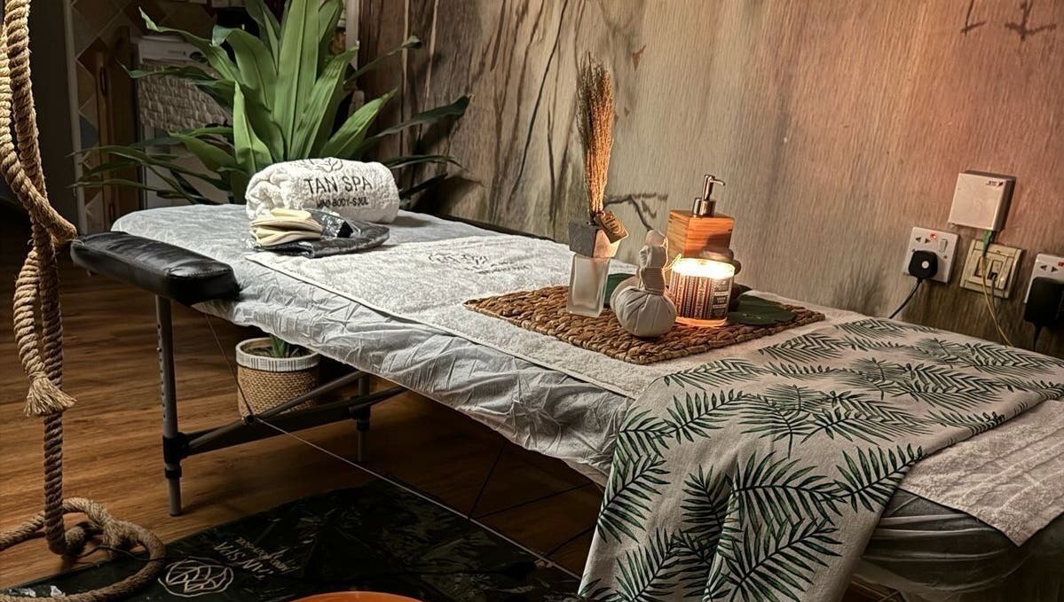 غرفة استرخاء في مركز تان سبا للخدمة المنزلية في الرياض، تتميز بإضاءة دافئة وديكور طبيعي.