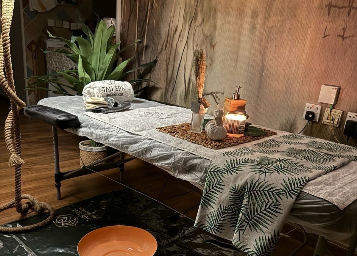 غرفة استرخاء في مركز تان سبا للخدمة المنزلية في الرياض، تتميز بإضاءة دافئة وديكور طبيعي.