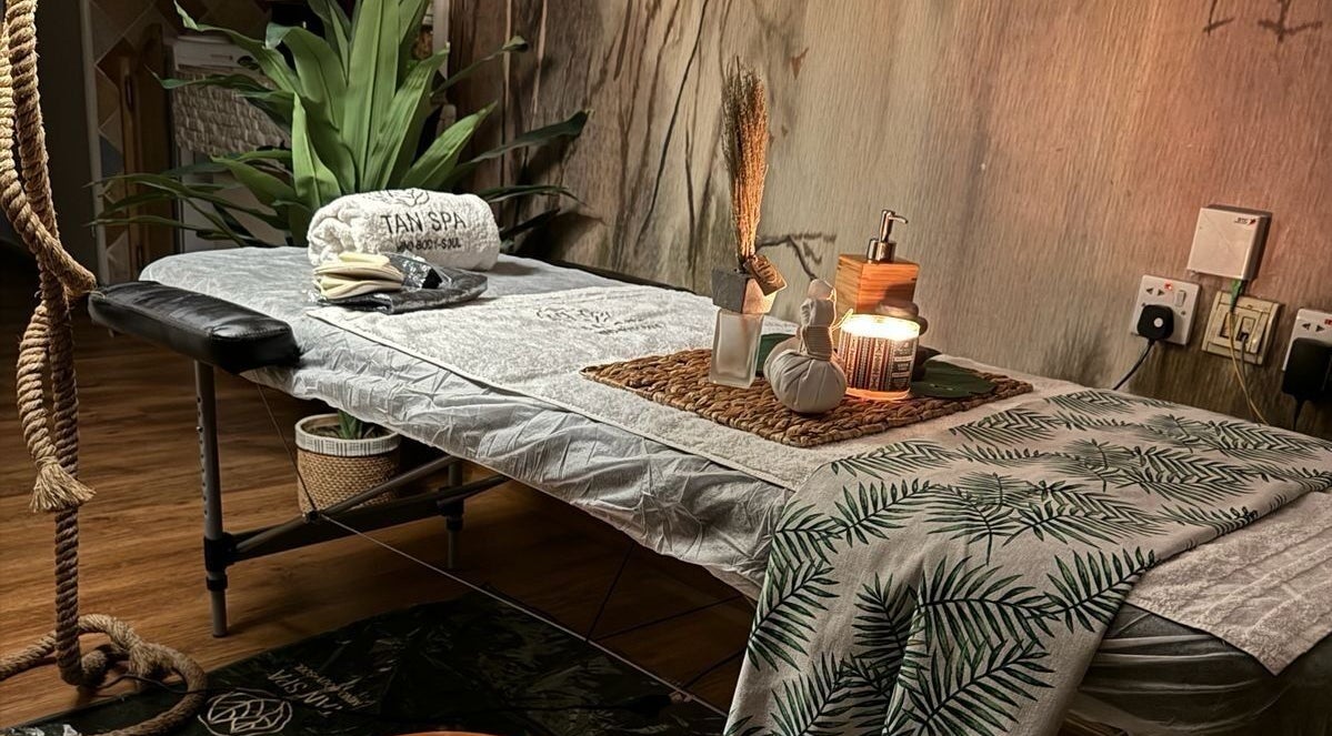 غرفة استرخاء في مركز تان سبا للخدمة المنزلية في الرياض، تتميز بإضاءة دافئة وديكور طبيعي.