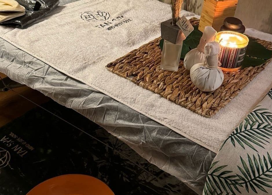 طاولة تدليك مزينة في مركز تان سبا للخدمة المنزلية، الرياض، تتميز بلمسات فاخرة لمزيد من الاسترخاء.