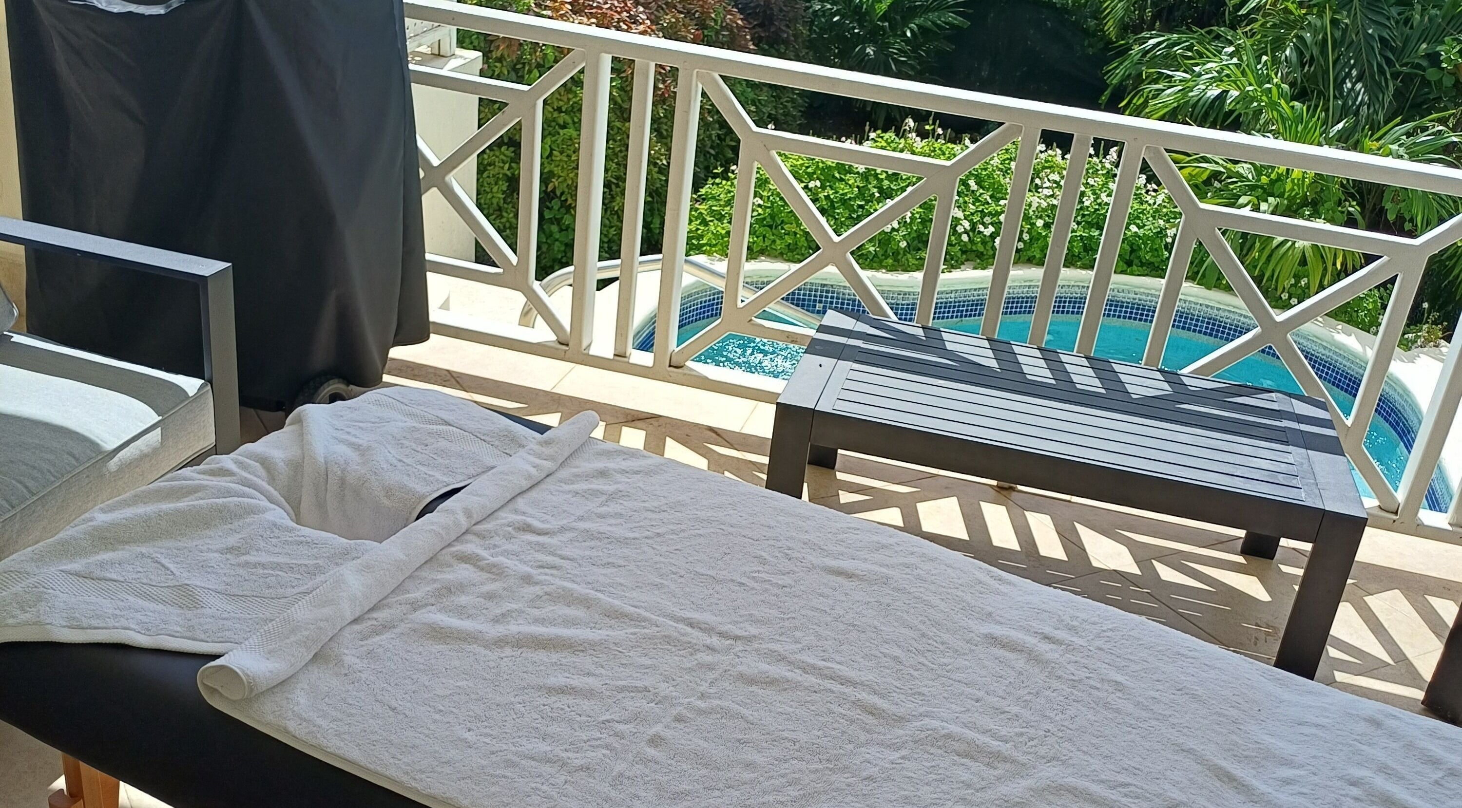 Outdoor massage table by pool at Kay La Vie The Spa, Bridgetown, Saint Michael, BB, offering a tranquil retreat.