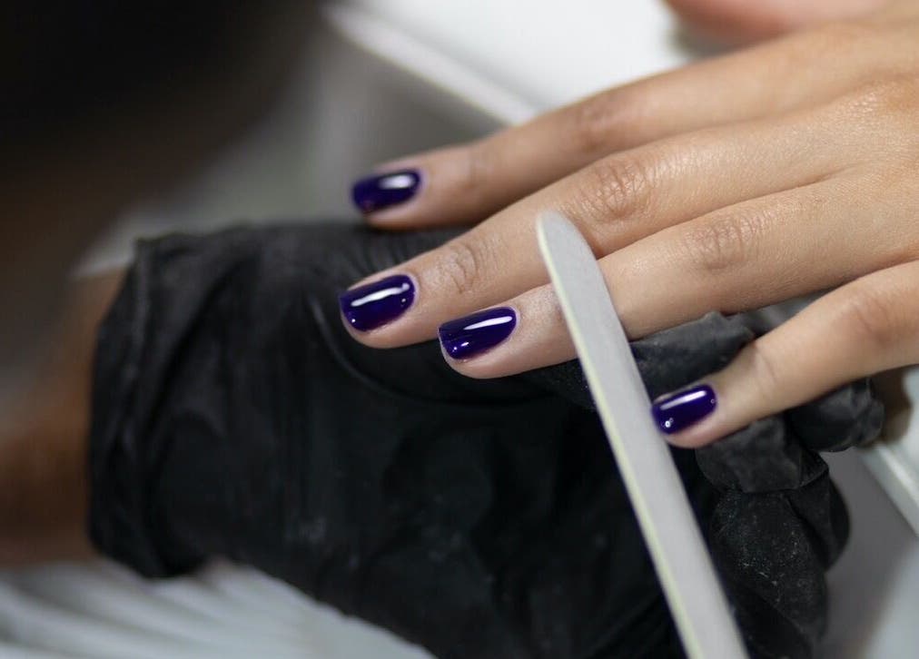 Elegant purple manicure being perfected at Nails by T, Harlow, England, GB.