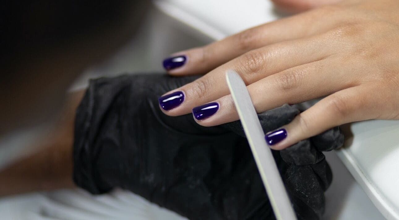Elegant purple manicure being perfected at Nails by T, Harlow, England, GB.