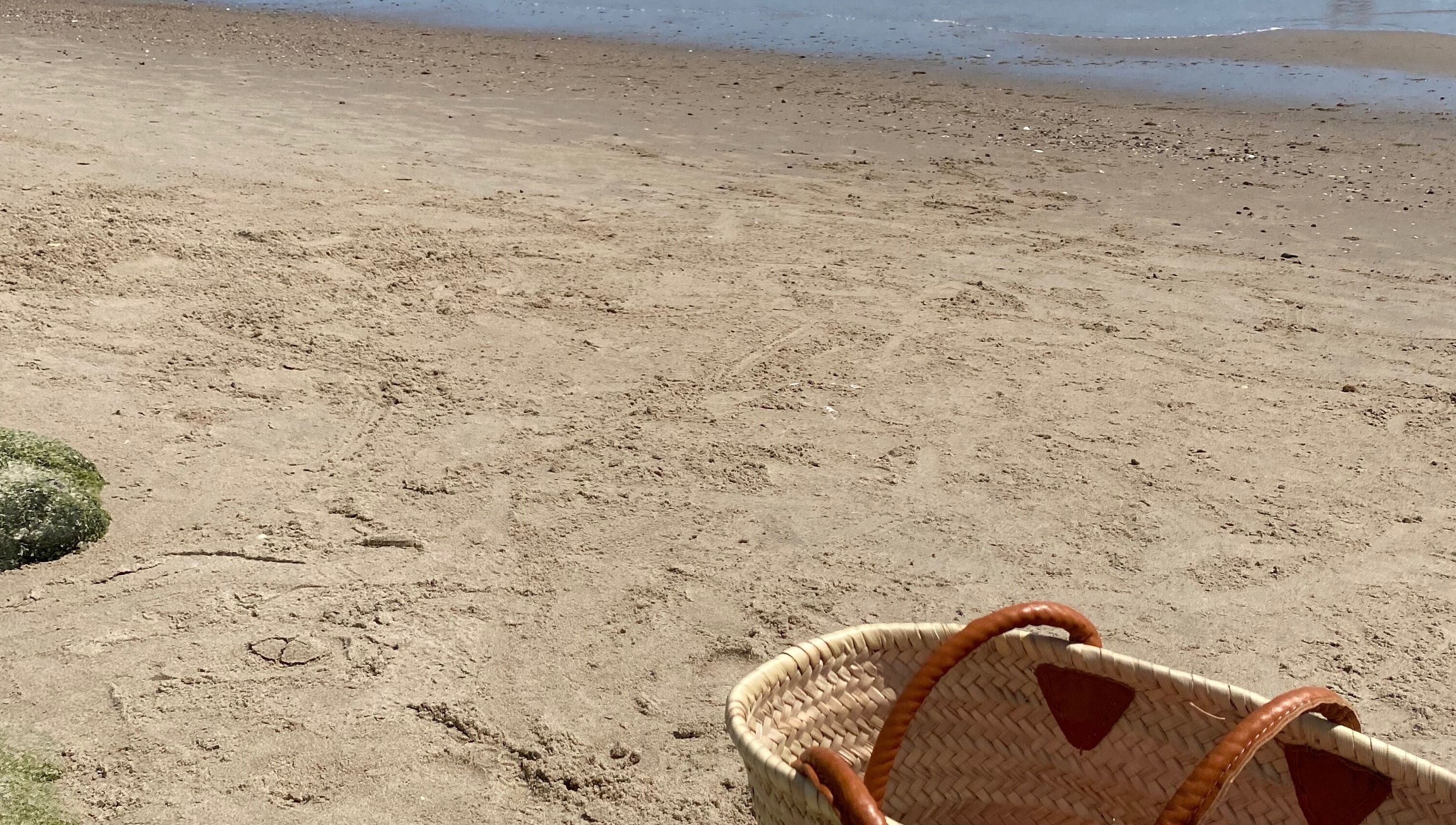 Basket on a sunny beach at Tanlines, IE, evoking relaxation.