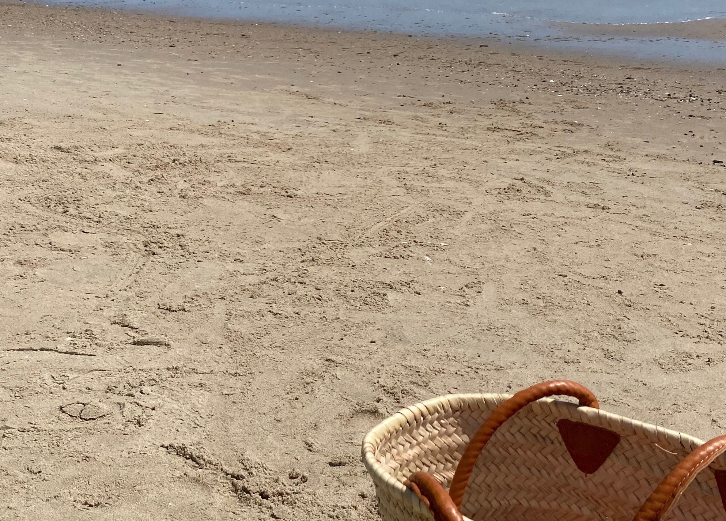 Basket on a sunny beach at Tanlines, IE, evoking relaxation.
