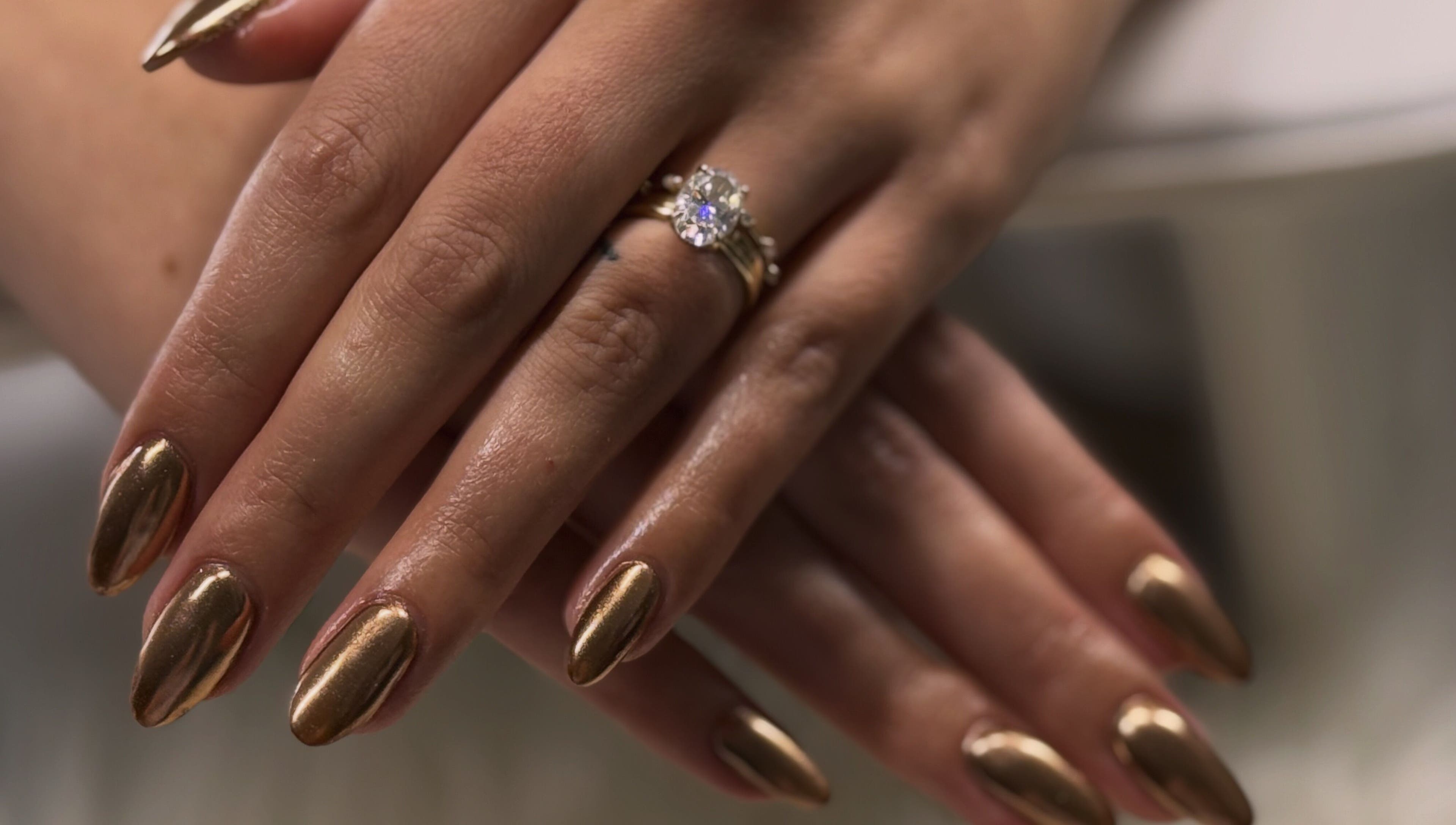 Elegant golden nails with a ring on display at Nailed by Krisana, Liberty Lake, Washington, US.