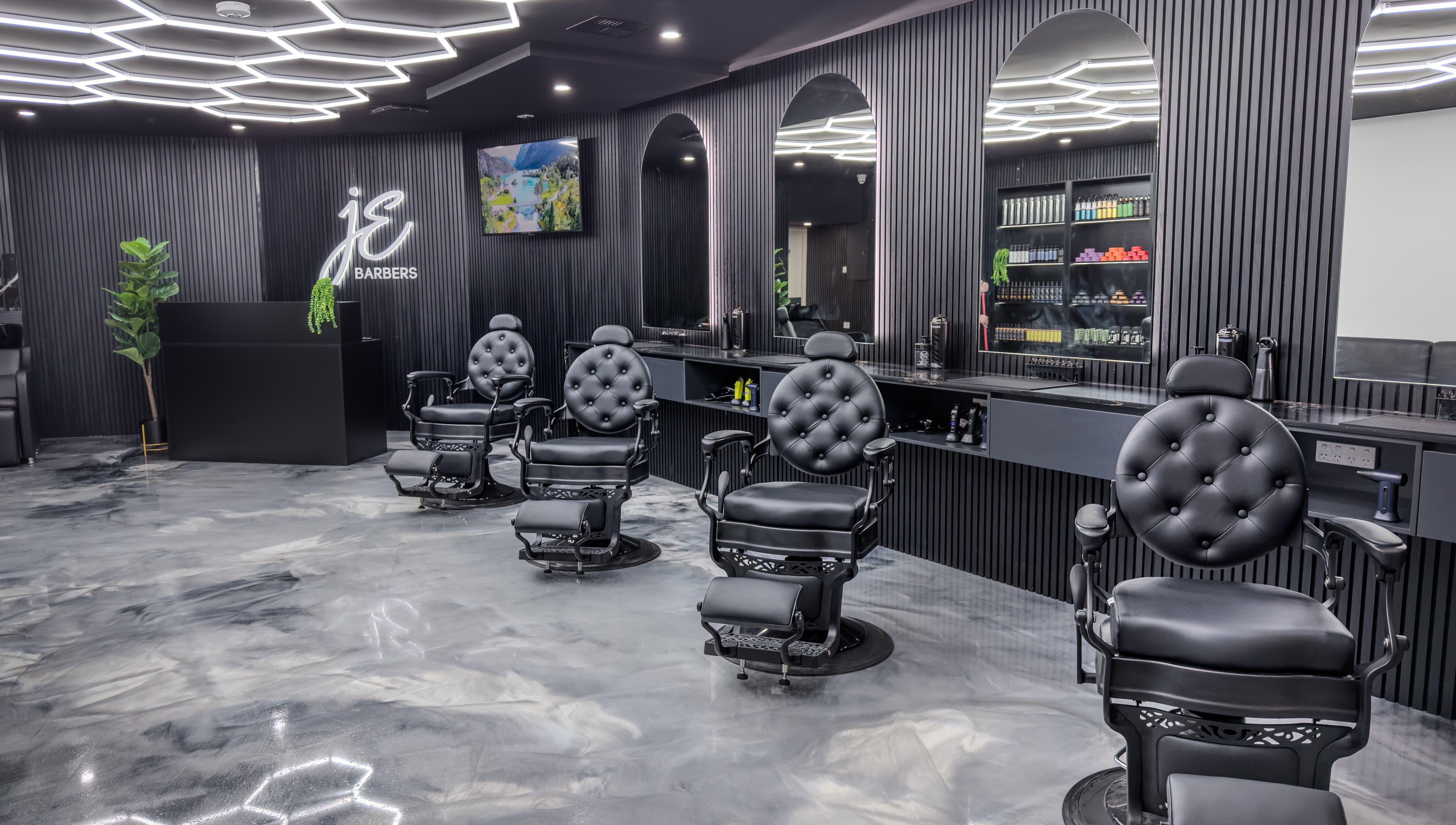 Interior of JE Barbers showing stylish black chairs and mirrors in Melbourne, Victoria, AU.