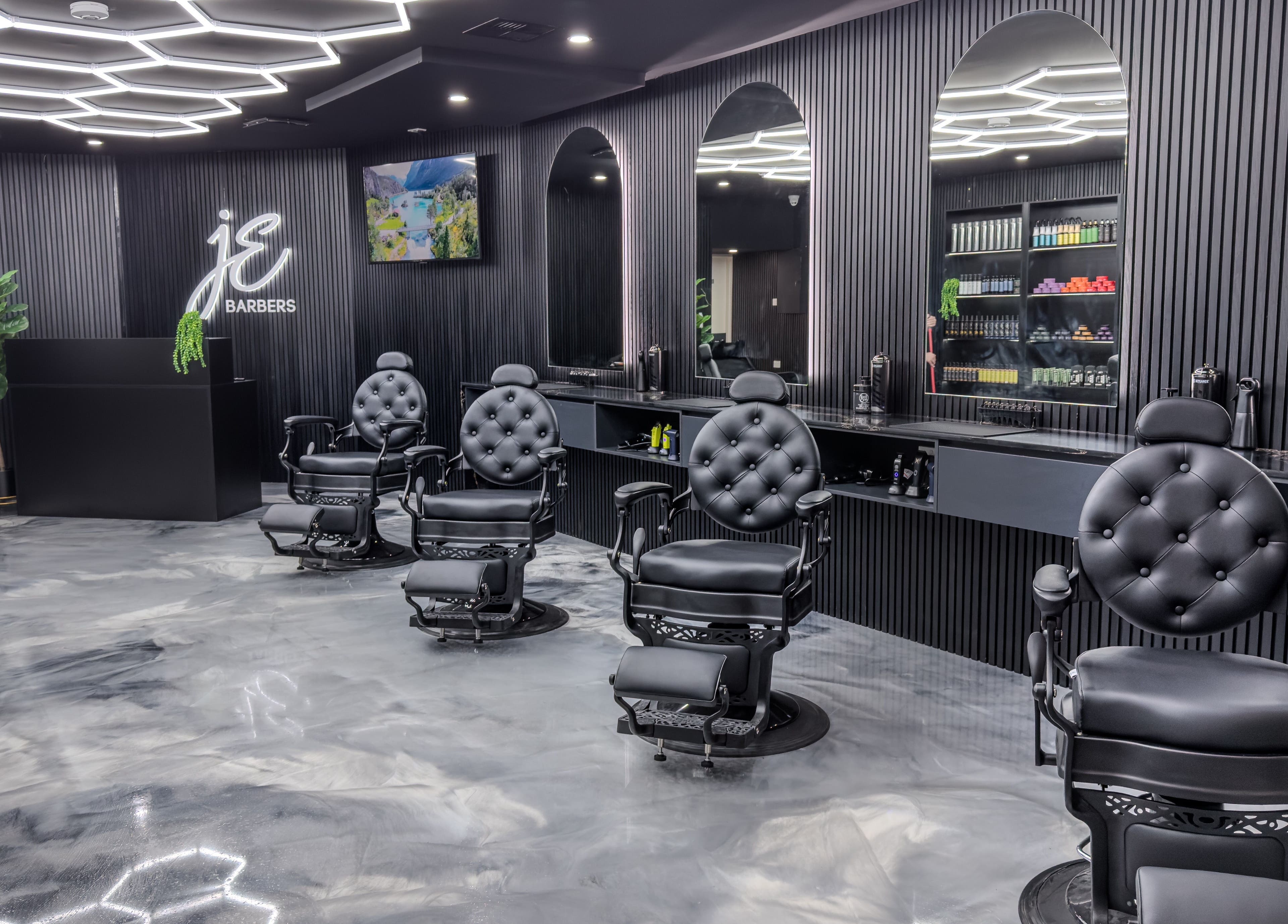 Interior of JE Barbers showing stylish black chairs and mirrors in Melbourne, Victoria, AU.