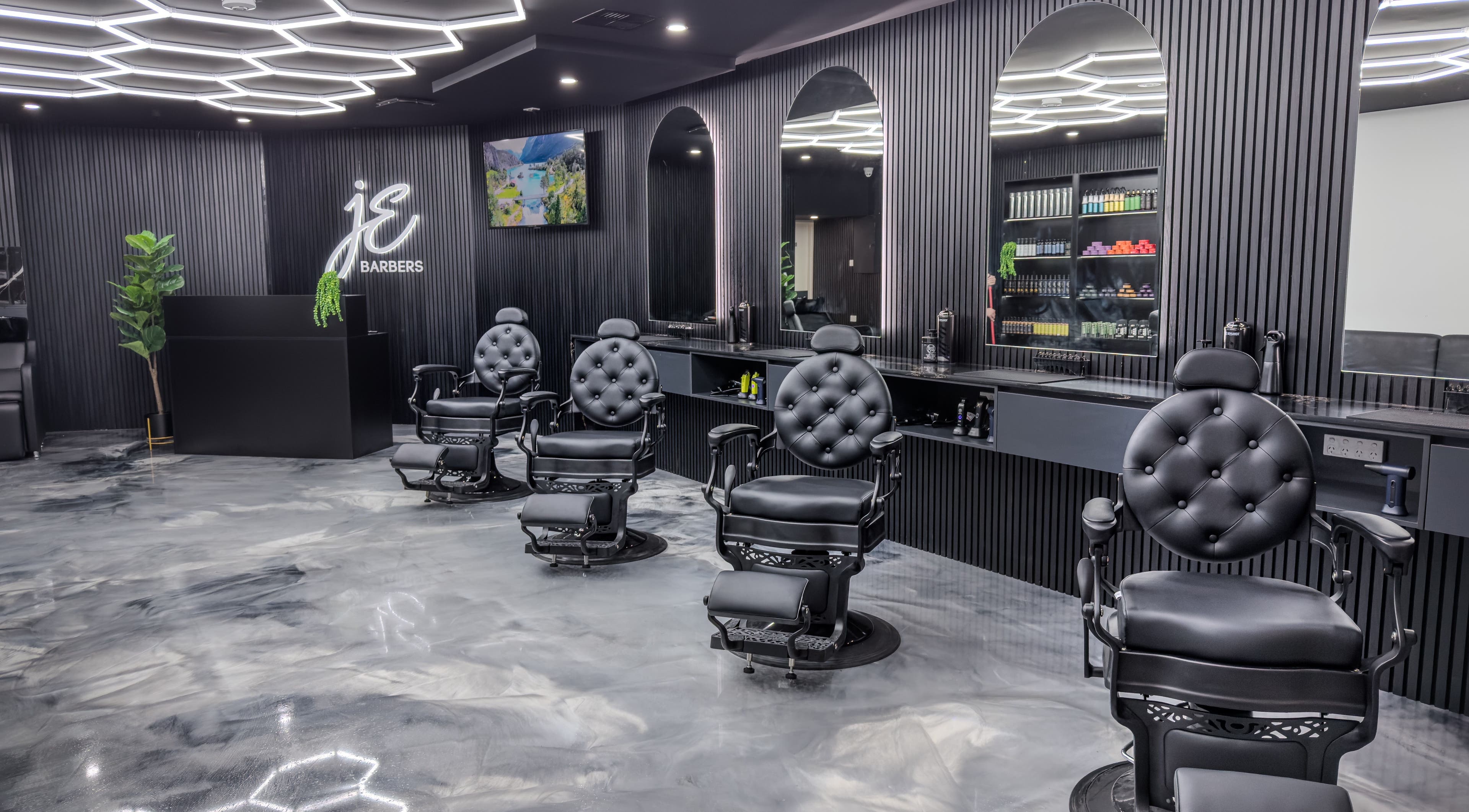 Interior of JE Barbers showing stylish black chairs and mirrors in Melbourne, Victoria, AU.