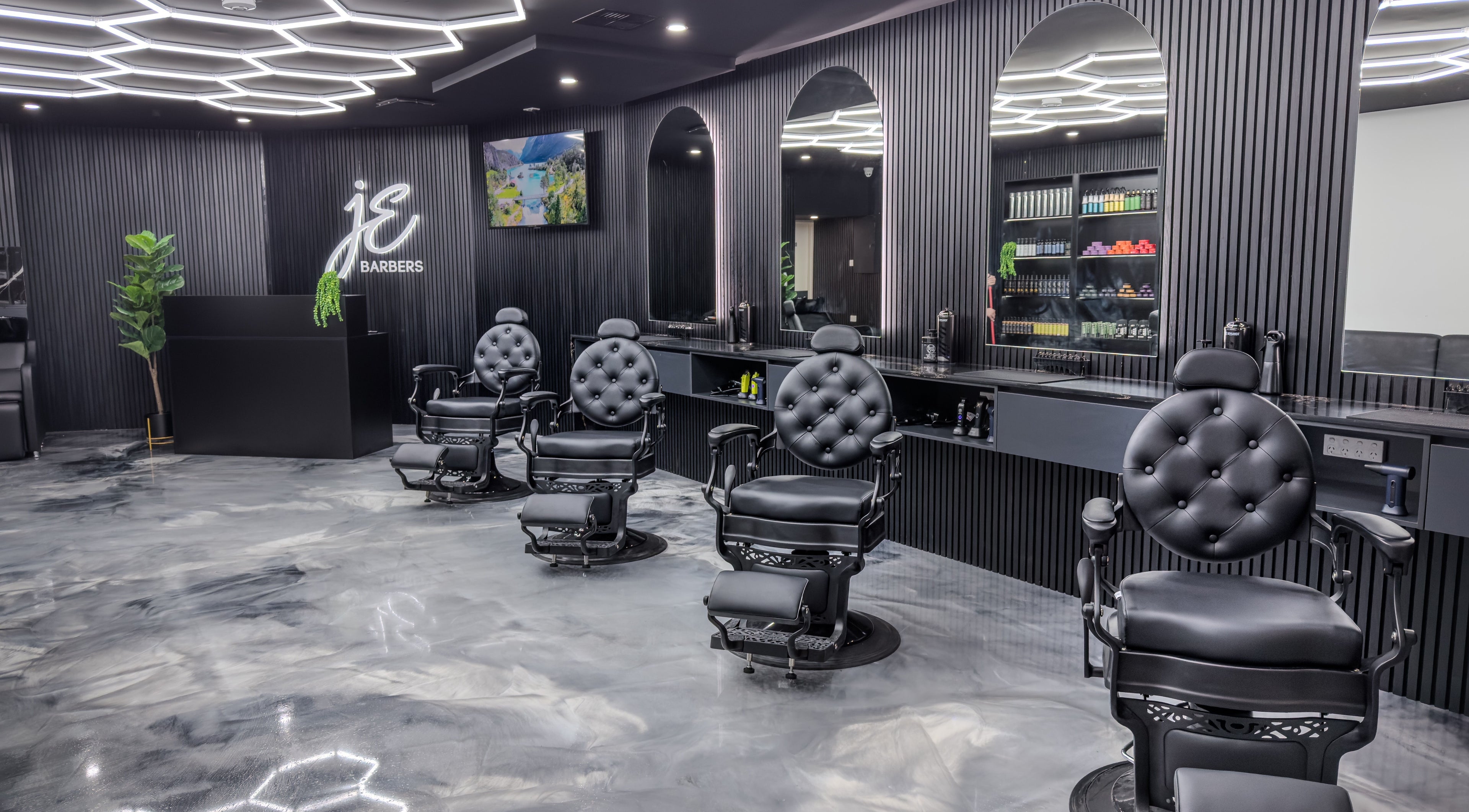 Interior of JE Barbers showing stylish black chairs and mirrors in Melbourne, Victoria, AU.