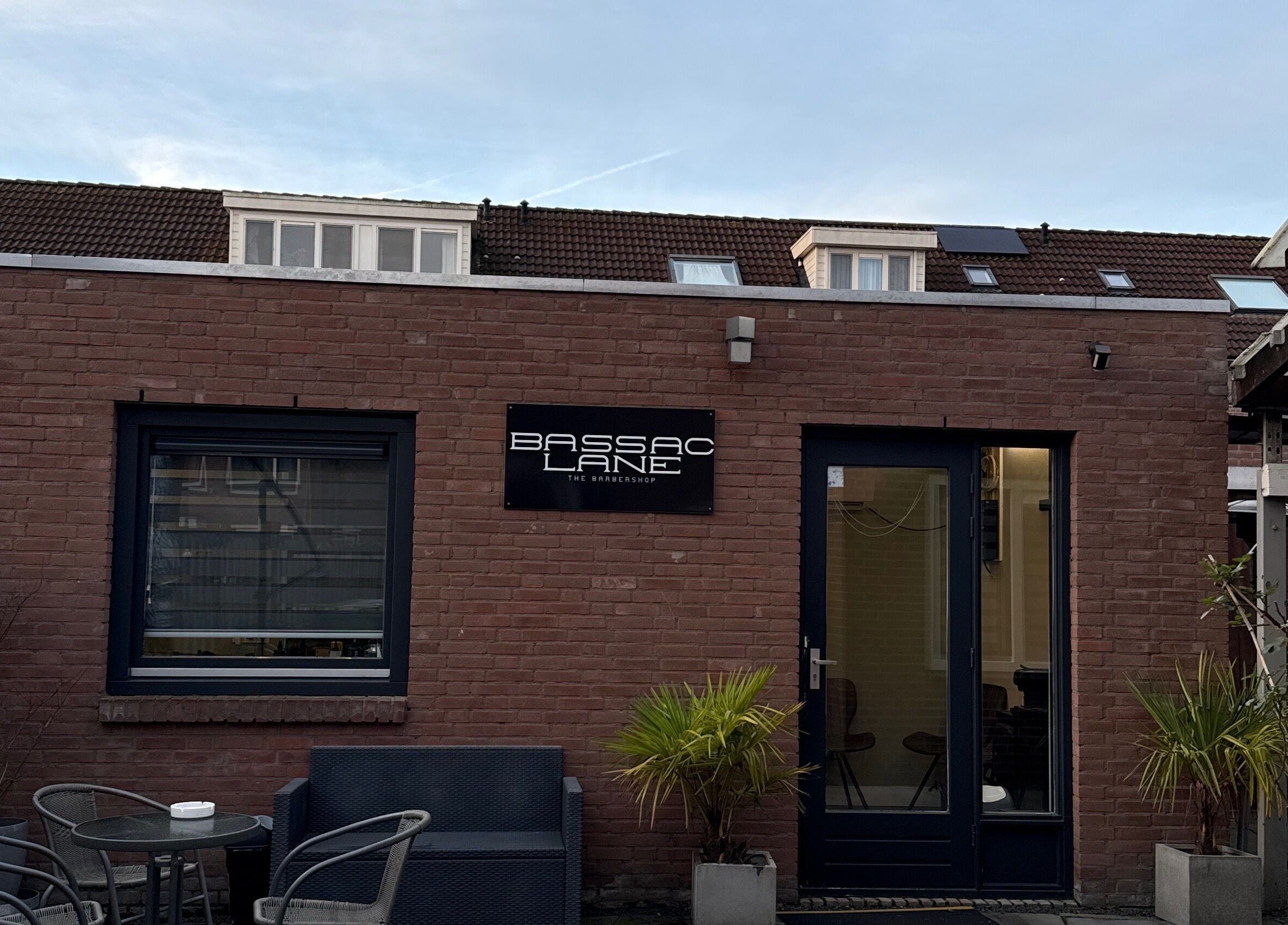 Vooraanzicht van Bassaclane, een wellnesslocatie in Breda, Noord-Brabant, NL, met moderne bakstenen muur.