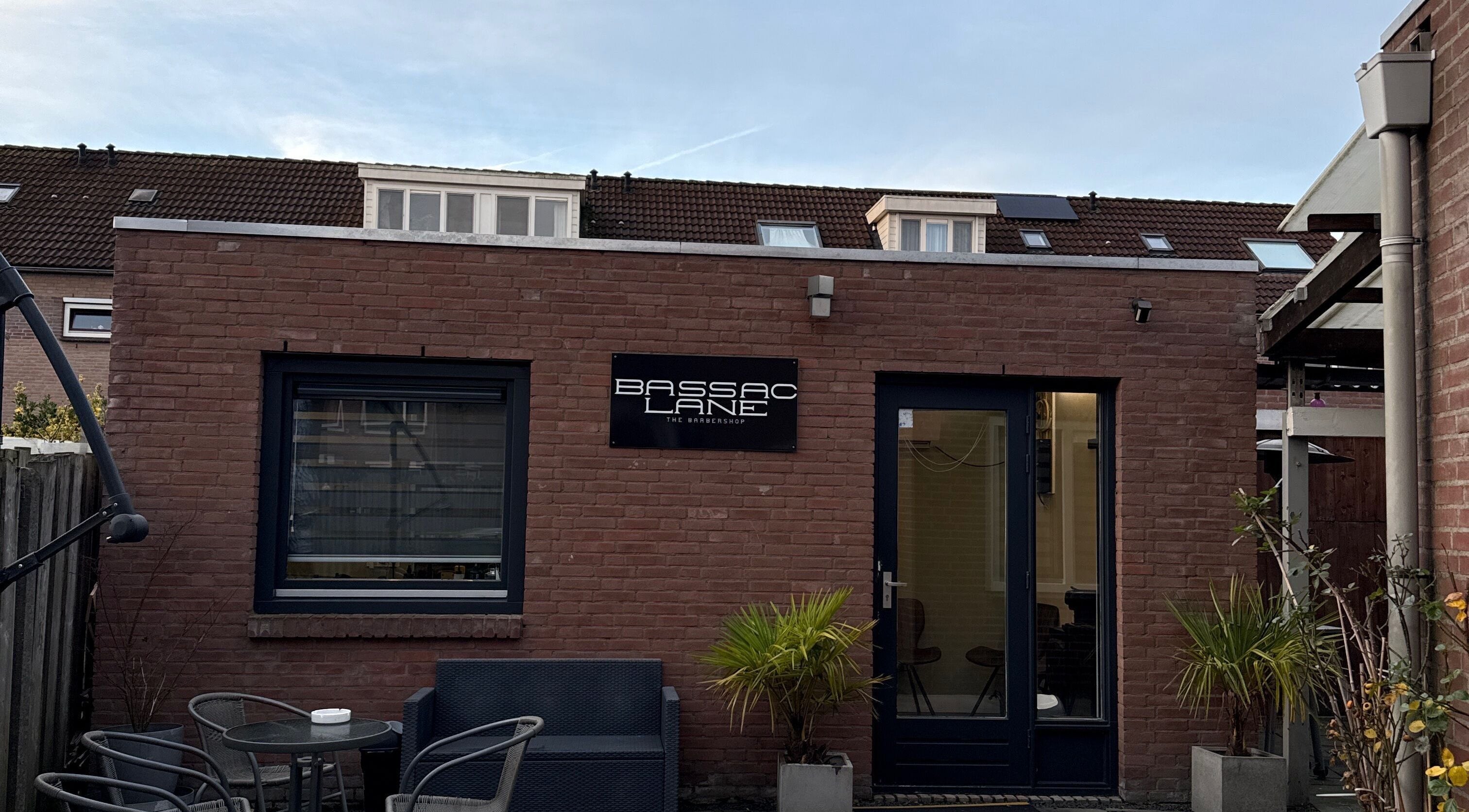 Vooraanzicht van Bassaclane, een wellnesslocatie in Breda, Noord-Brabant, NL, met moderne bakstenen muur.