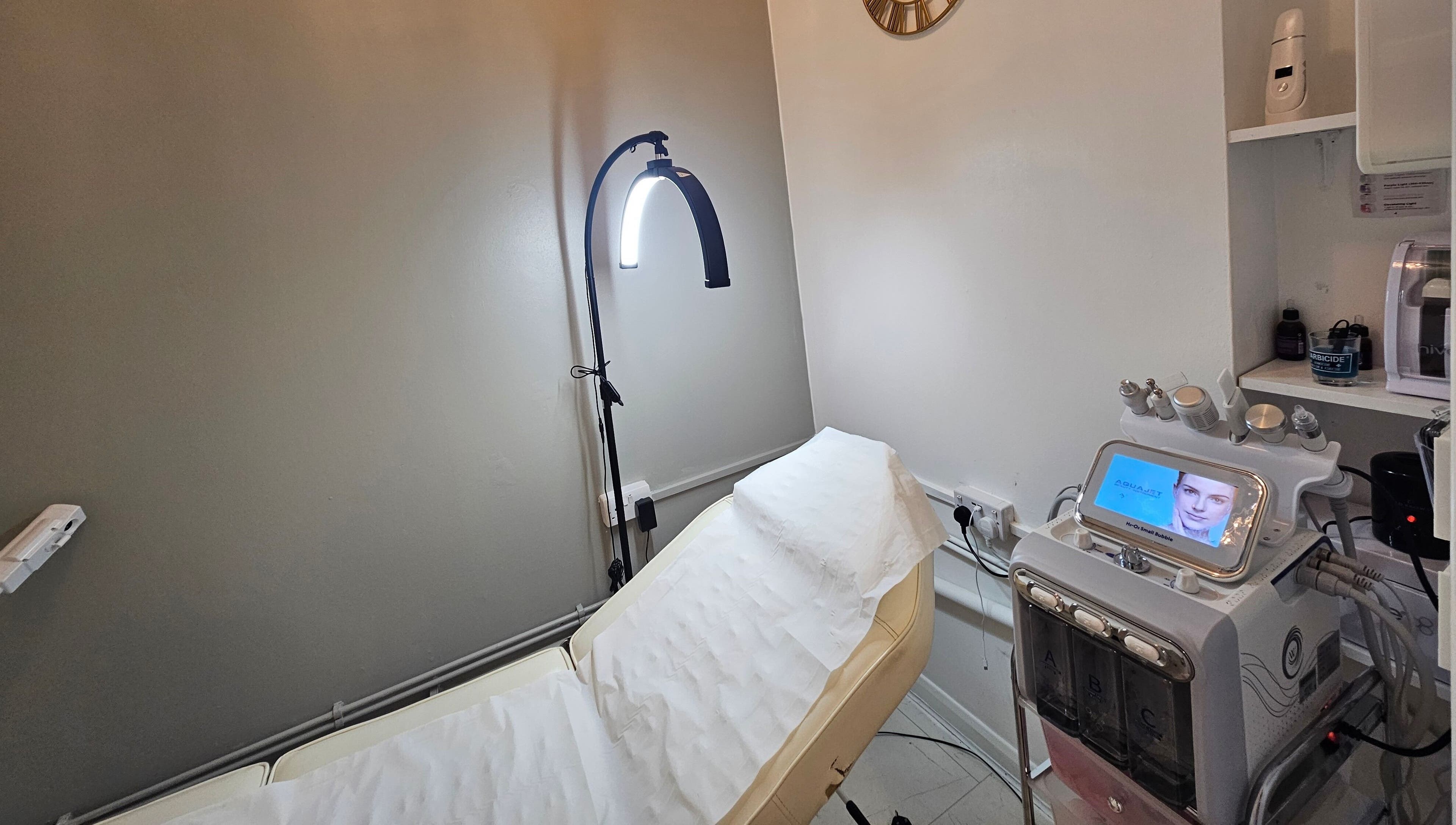 Modern treatment room at Pure Beauty Lounge, Hampton, England, GB, equipped with advanced skincare technology.