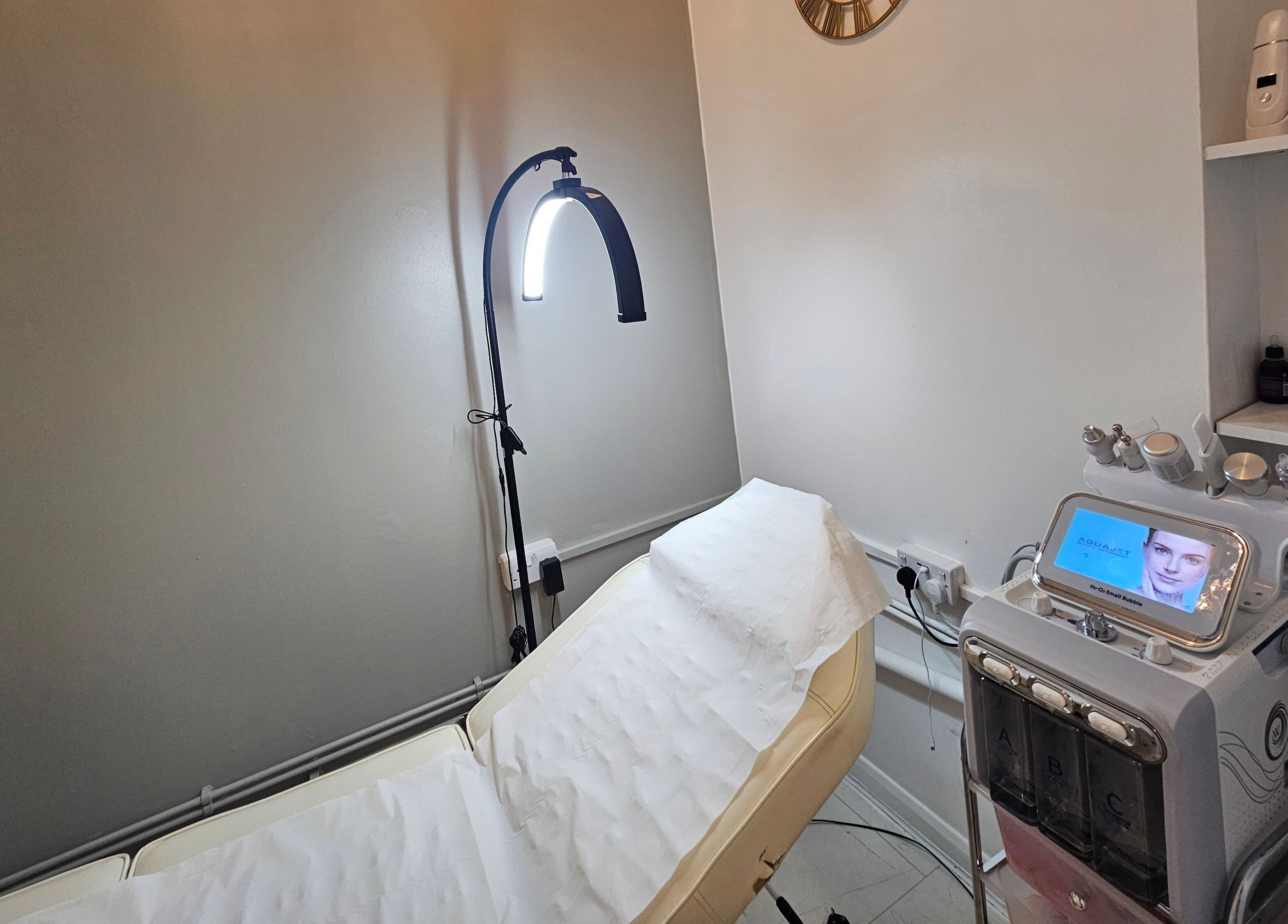 Modern treatment room at Pure Beauty Lounge, Hampton, England, GB, equipped with advanced skincare technology.