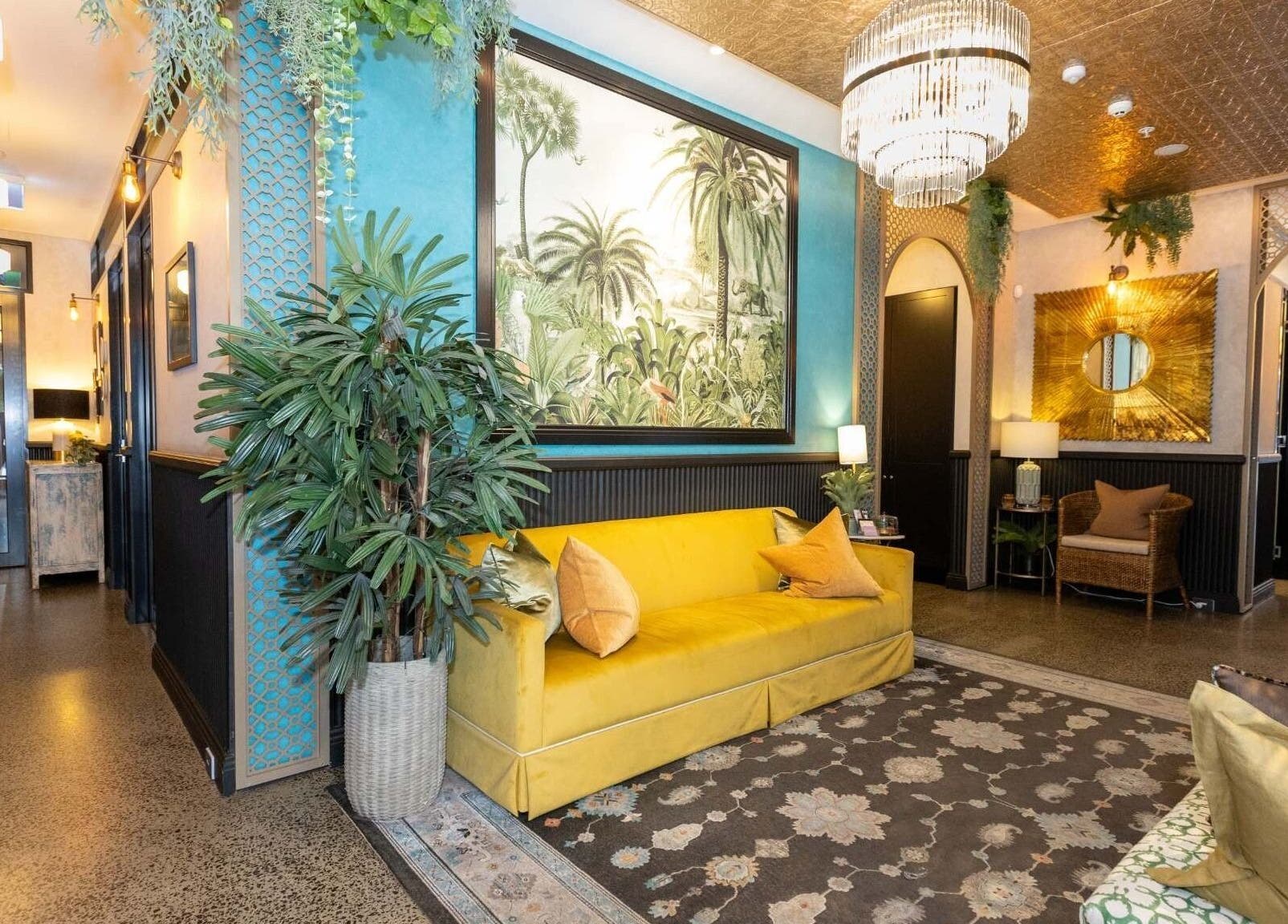 Chic lobby at Cry Baby Cosmetic Ink, Melbourne, Victoria, AU with tropical decor and yellow couch.