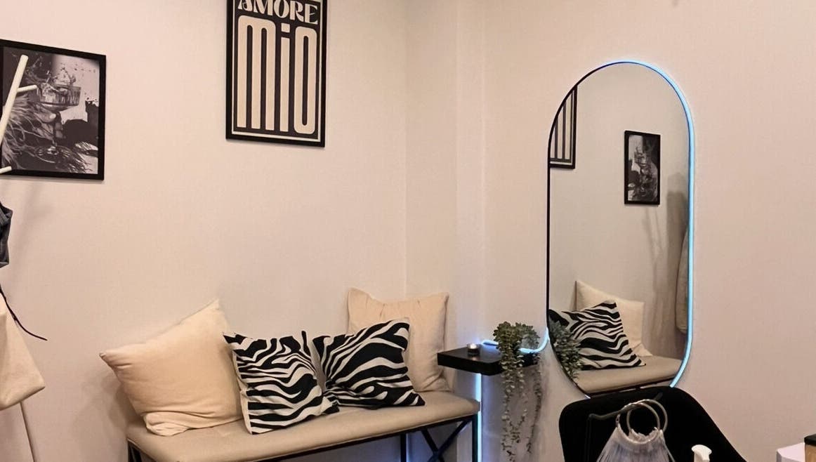 Sala de espera elegante en Gia, Mataró, Catalunya, ES con sofá y espejo iluminado.