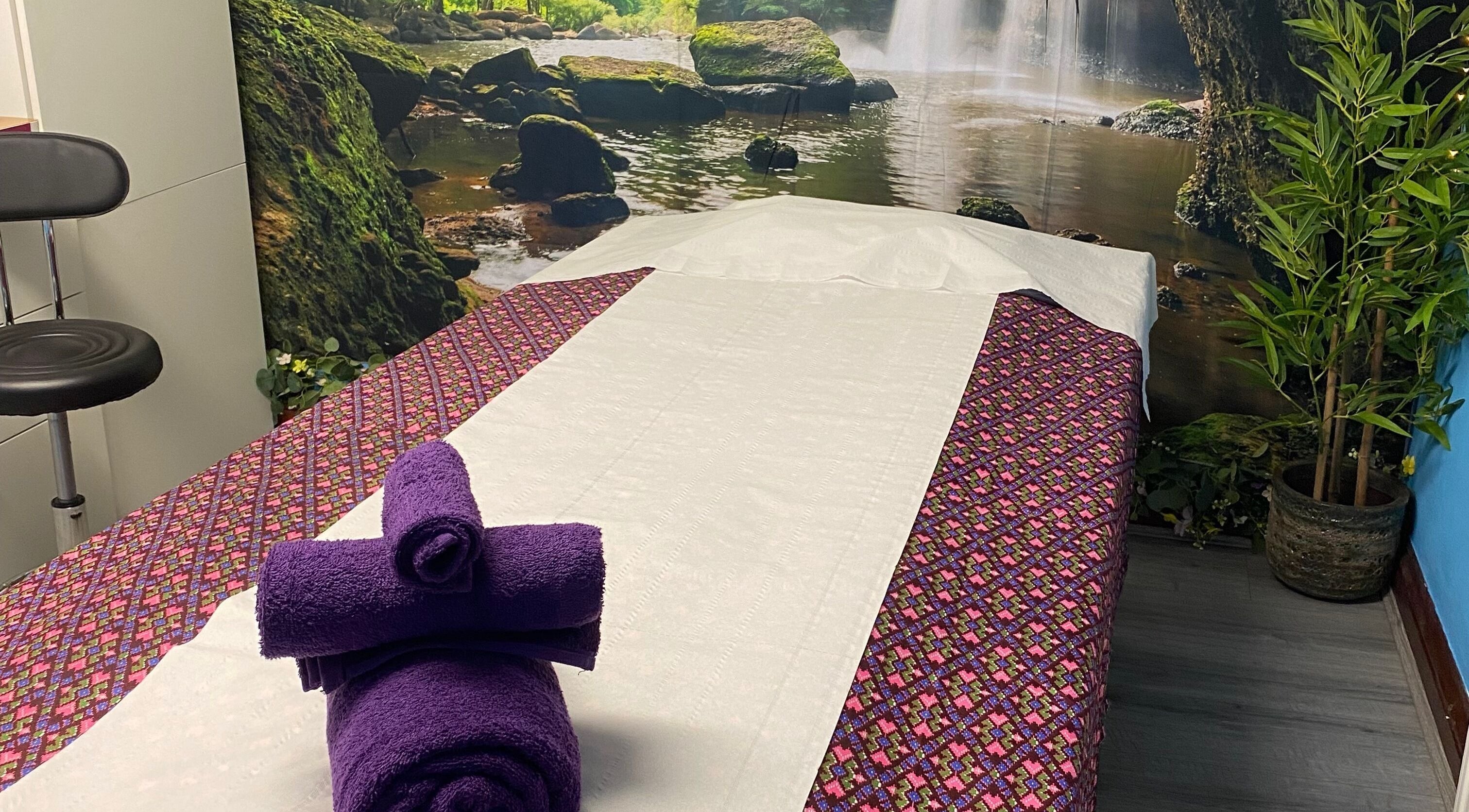 Tranquil massage room at Kannika Thai Massage Therapy, Winnersh, England with nature decor and cozy bedding.