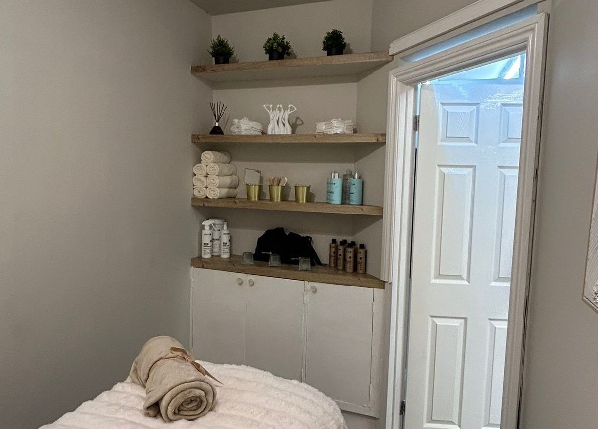 Cozy treatment room at Beauty by Courtney, Plymouth, England, GB, with neatly arranged towels and products.