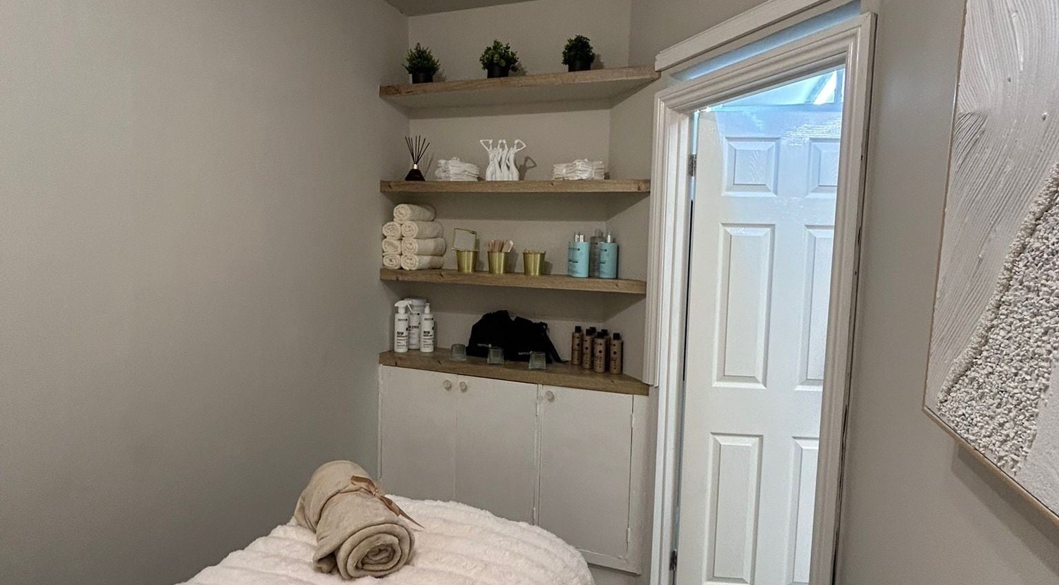 Cozy treatment room at Beauty by Courtney, Plymouth, England, GB, with neatly arranged towels and products.