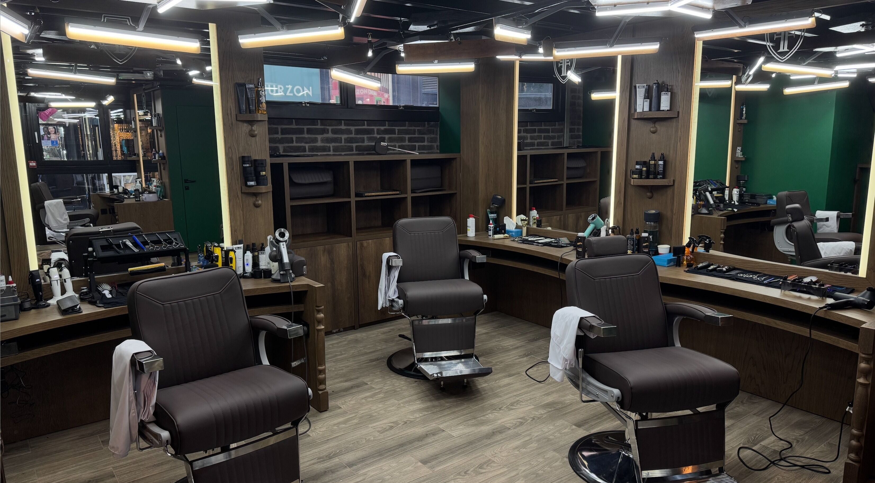 Elegant interior of Frisor Barbeshop in London, England, GB, featuring modern barber chairs and mirrored stations.