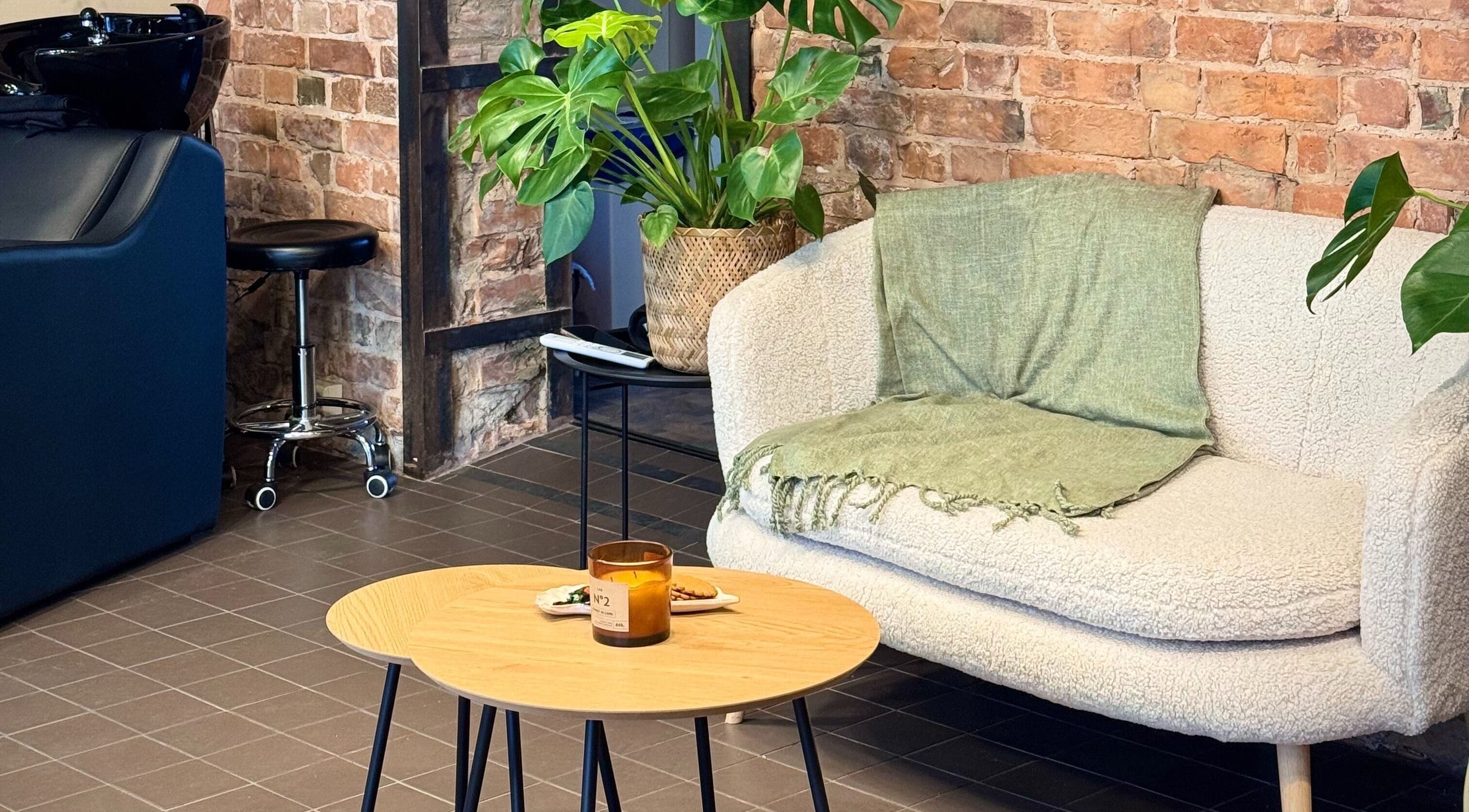 Cozy seating area with plants at MAE Beauty Studio, Rīga, LV, offering a relaxing atmosphere.