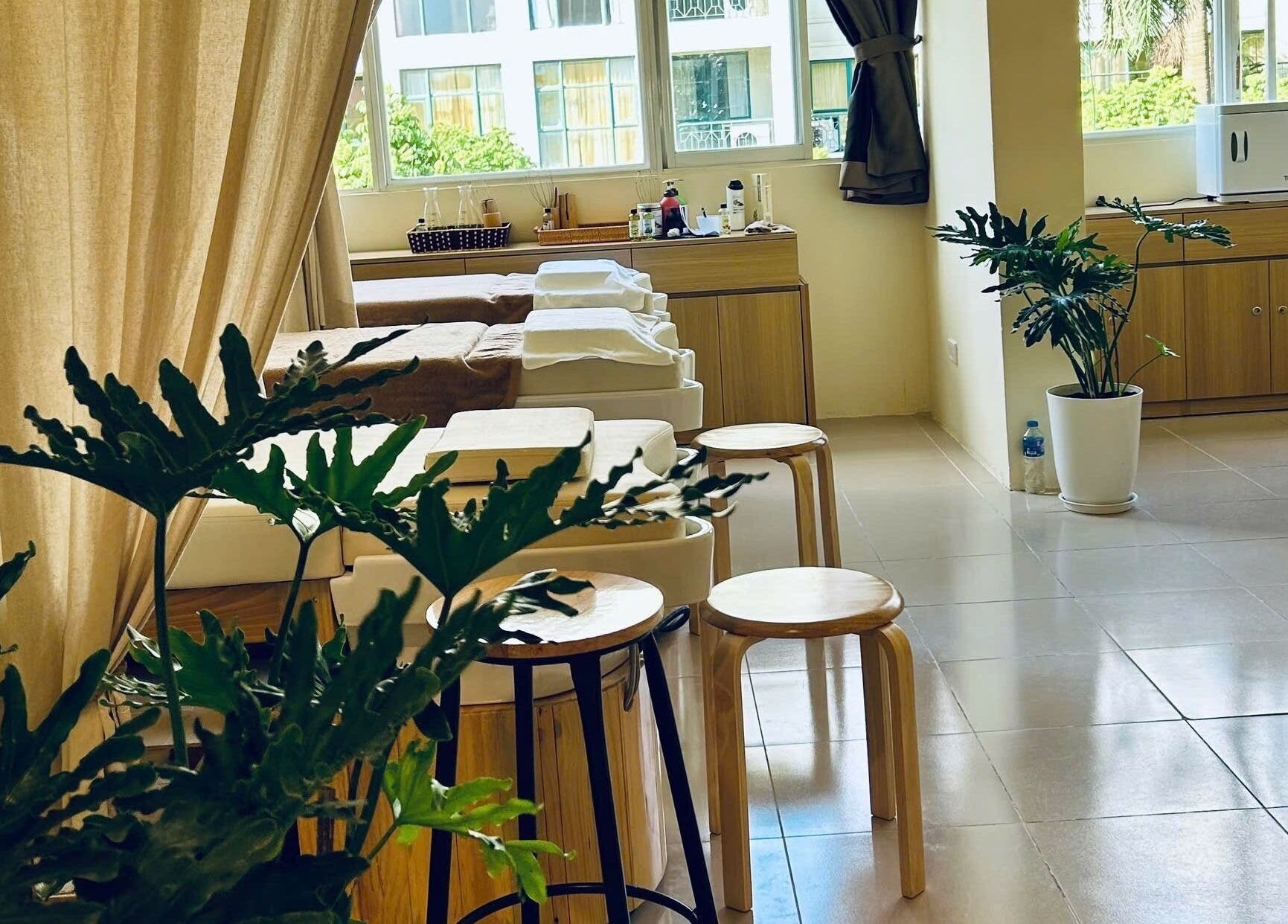 Relaxing spa interior at Tropi Q - Head herbal spa, Hà Nội, VN, featuring cozy wooden decor and green plants.