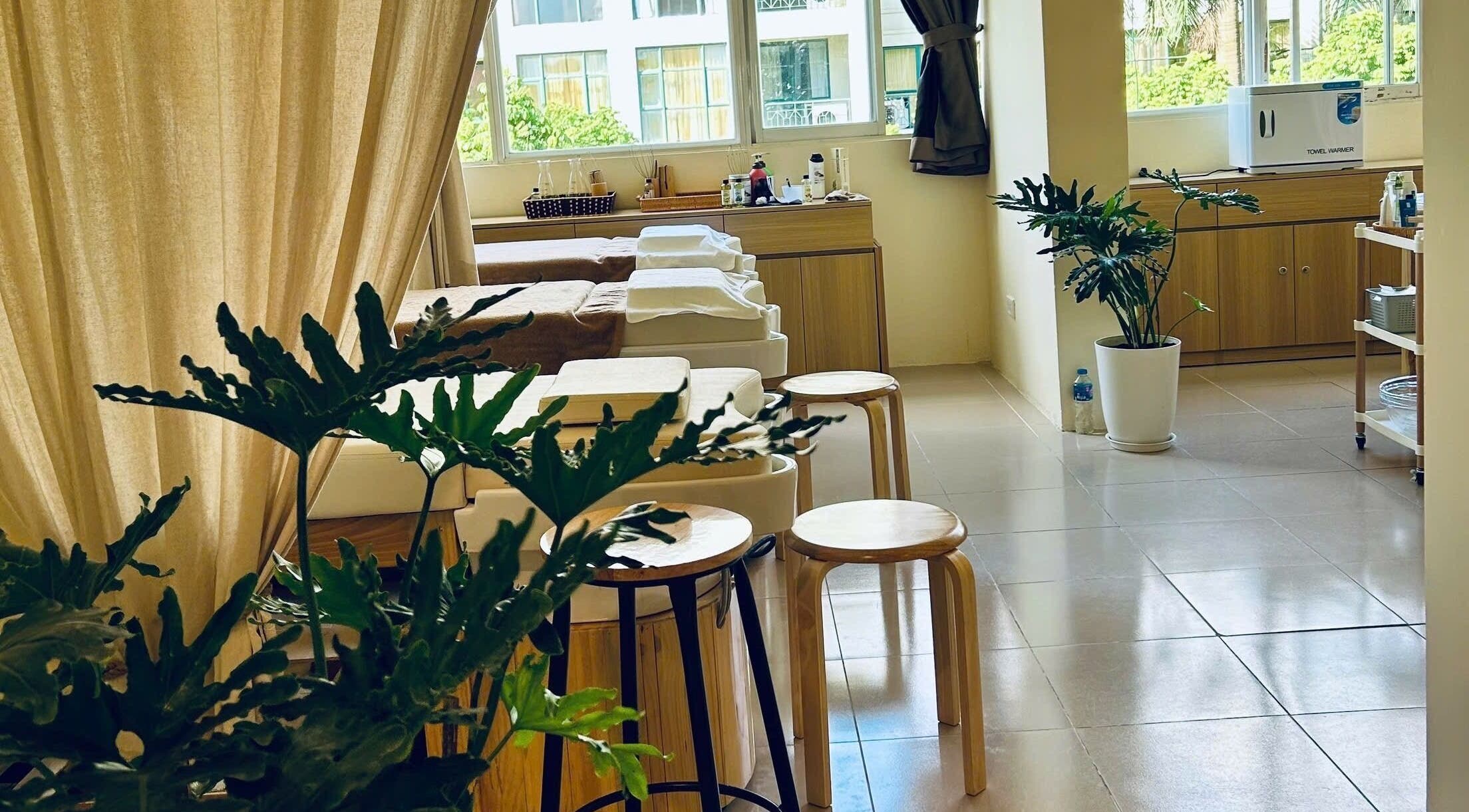 Relaxing spa interior at Tropi Q - Head herbal spa, Hà Nội, VN, featuring cozy wooden decor and green plants.