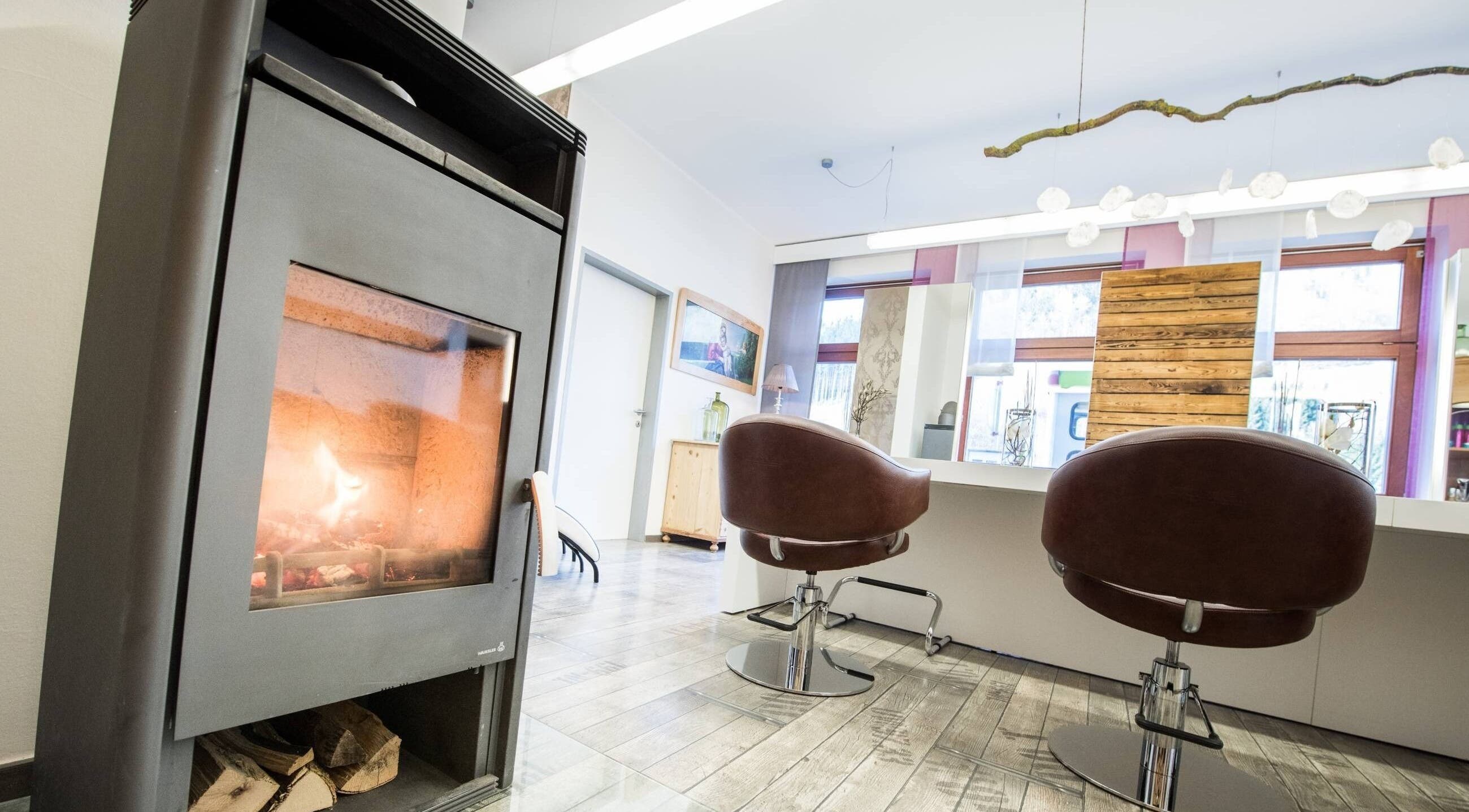 Warm salon at Aurion Labs in Wien, Wien, AT with stylish chairs and a cozy fireplace setting.