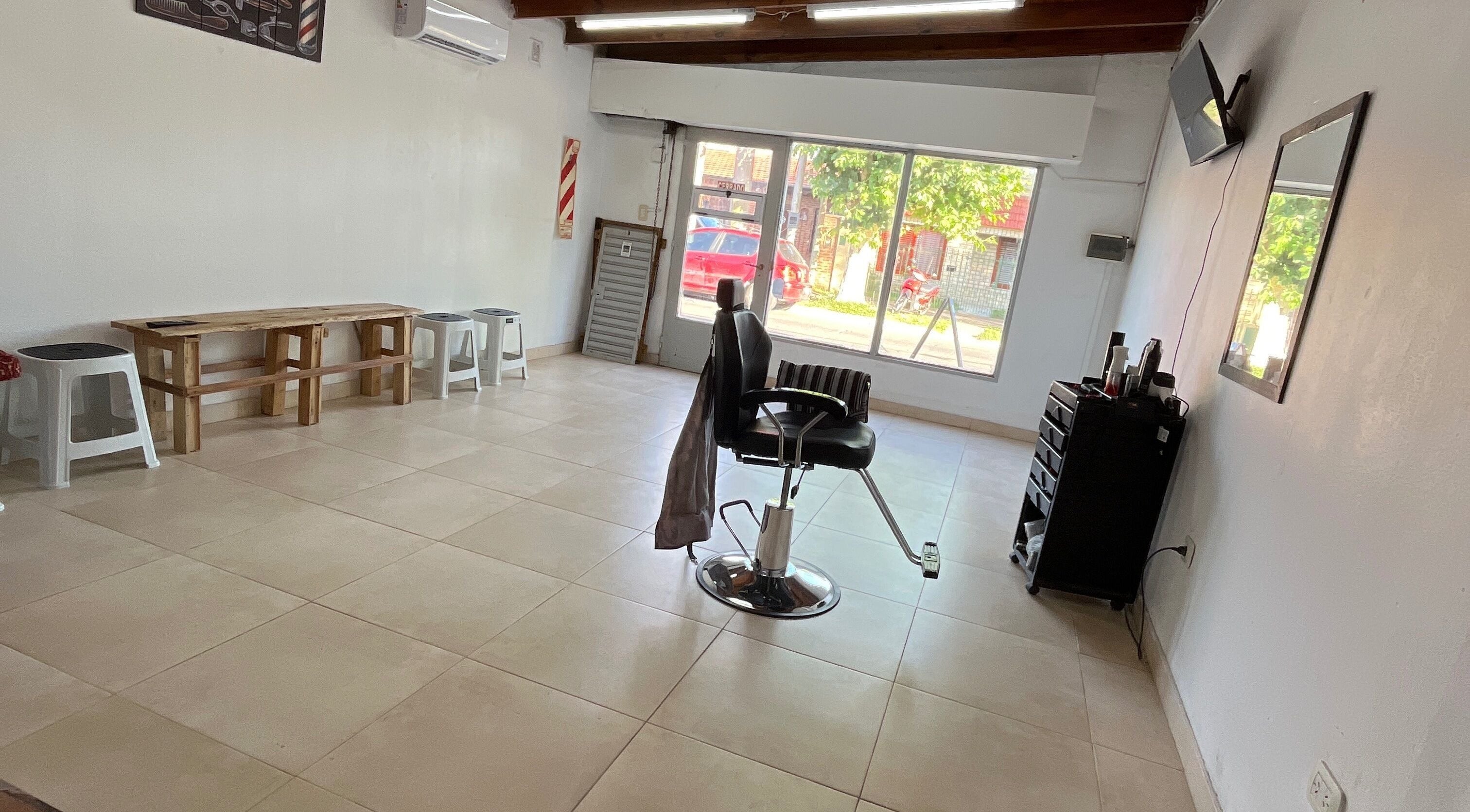 Interior de KAIZEN BARBERÍA en Ensenada, Provincia De Buenos Aires, AR con silla de barbero y vista exterior.