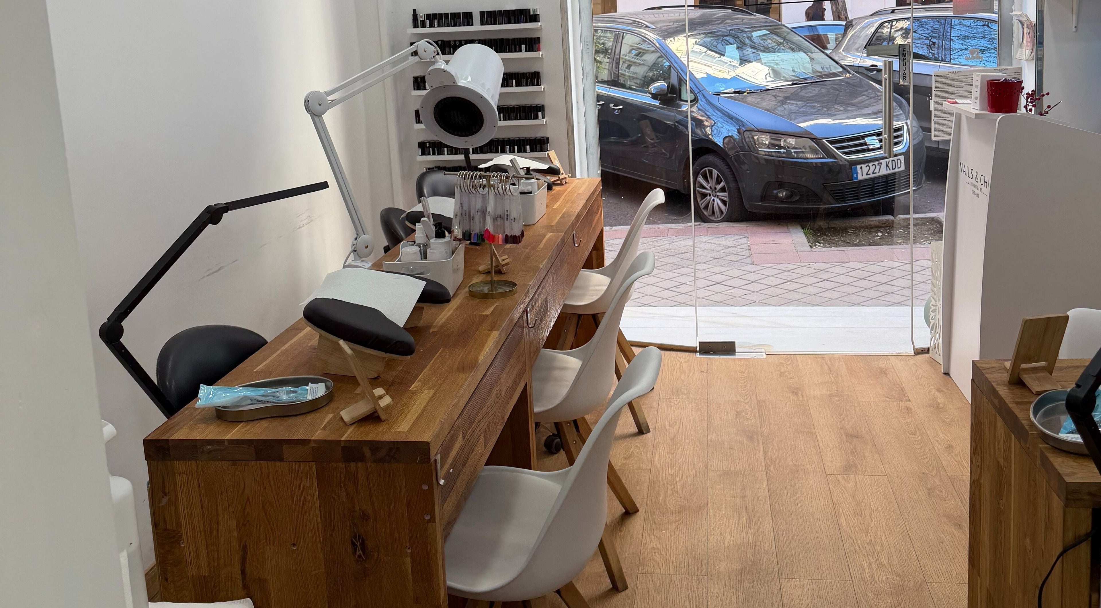 Mesa de manicura en Nails & Chill, Madrid, Comunidad De Madrid, ES con sillas blancas modernas.