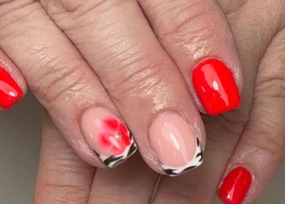Vibrant red nails with creative design at Hollie’s Nails in Radcliffe, England, GB.