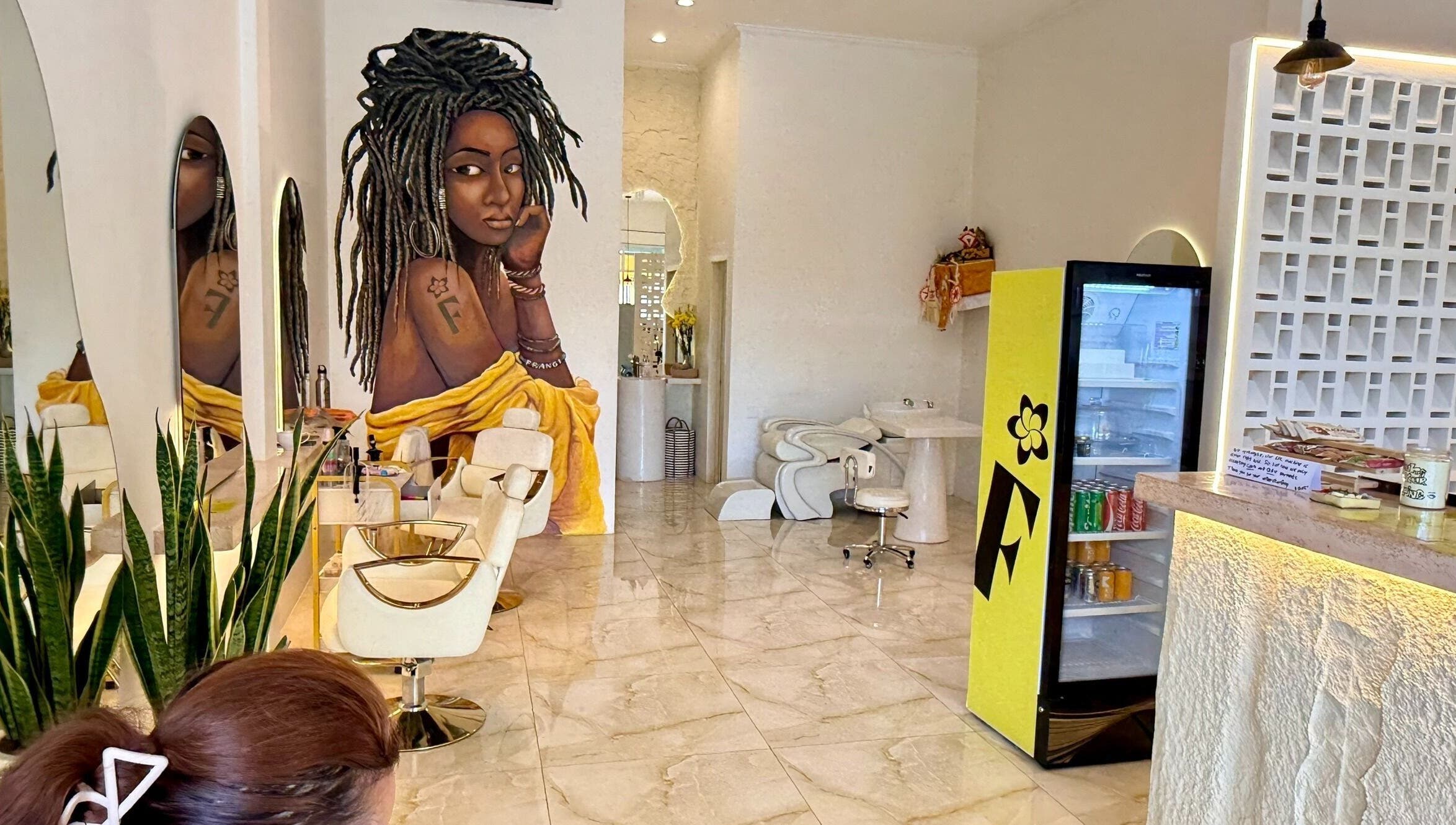 Modern interior of Frangi Braids Salon in Bali, Bali, ID, featuring stylish decor and vibrant mural art.
