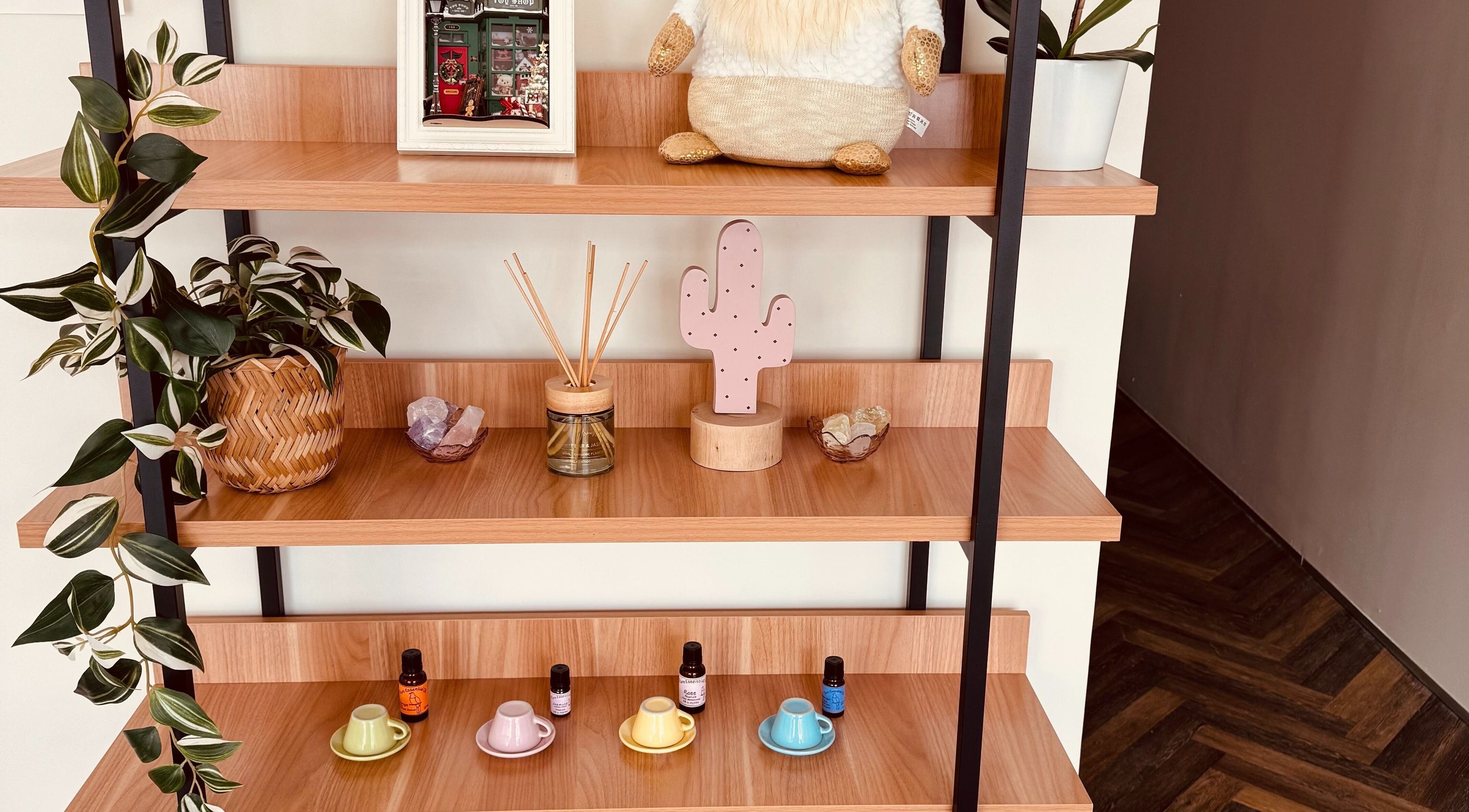 Decorative shelf at Zenova Massage in Auckland, Auckland, NZ with plants, crystals, and essential oils.