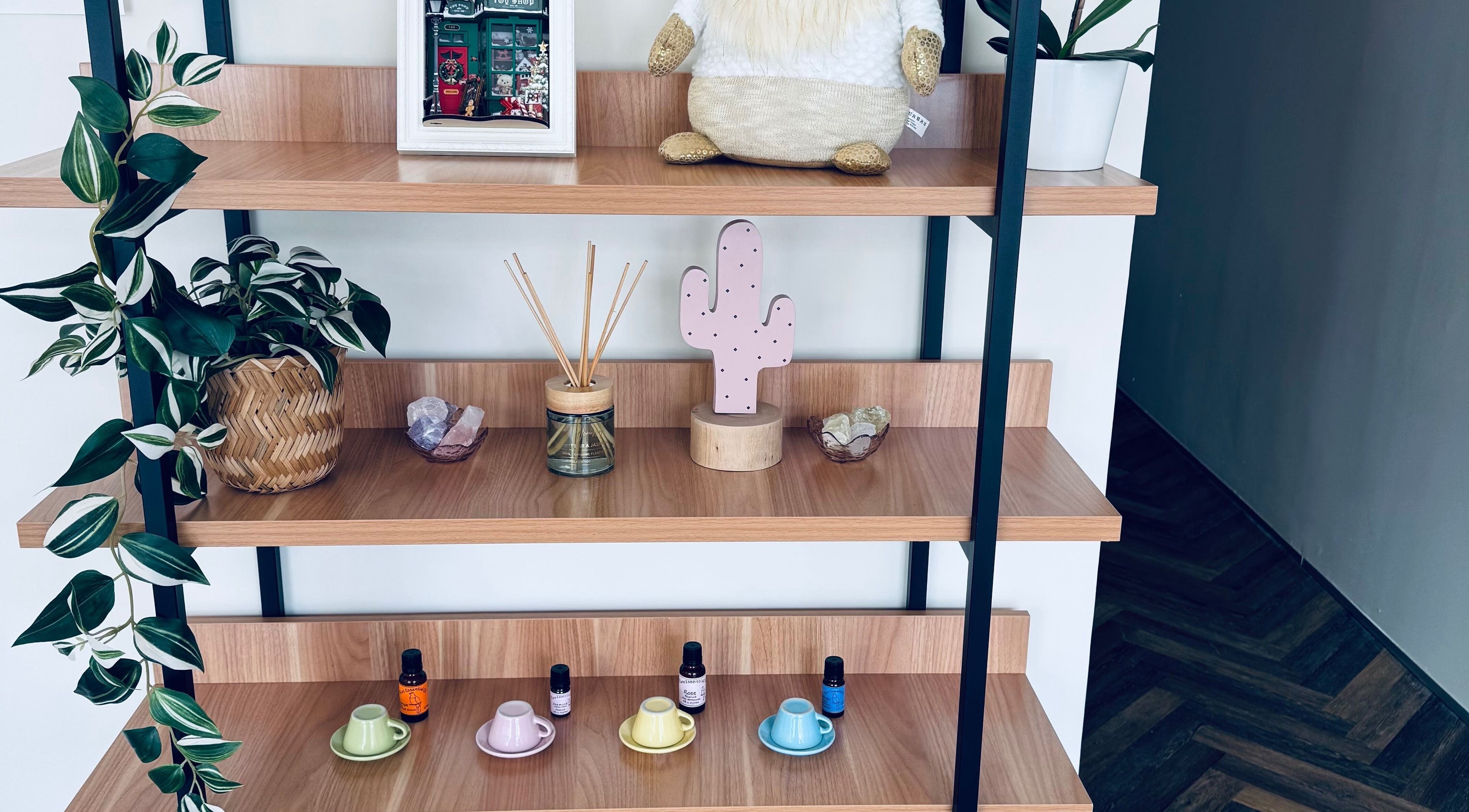 A styled shelf at Zenova Massage, Auckland, NZ with plants, crystals, and essential oils.