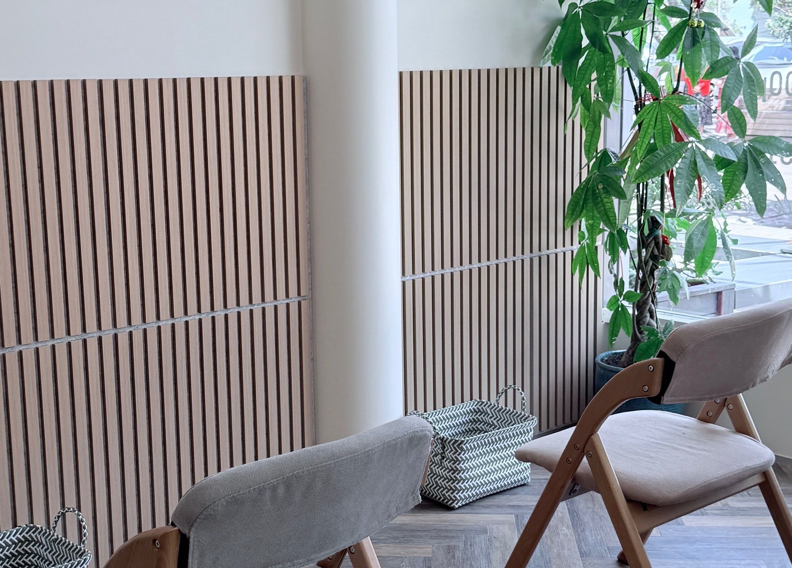 Calm seating area at Zenova Massage in Auckland, Auckland, NZ with wooden decor and lush plant.