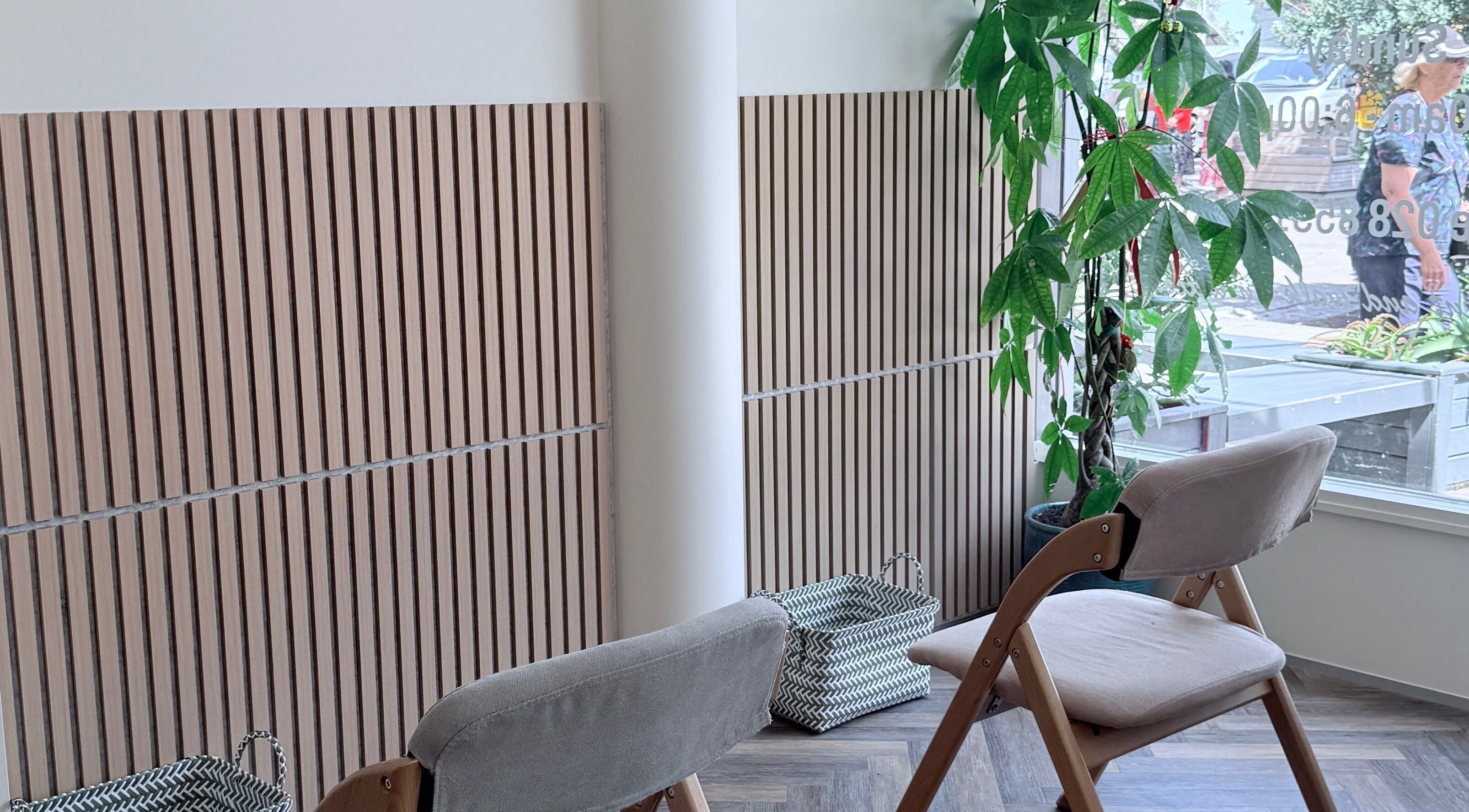 Calm seating area at Zenova Massage in Auckland, Auckland, NZ with wooden decor and lush plant.