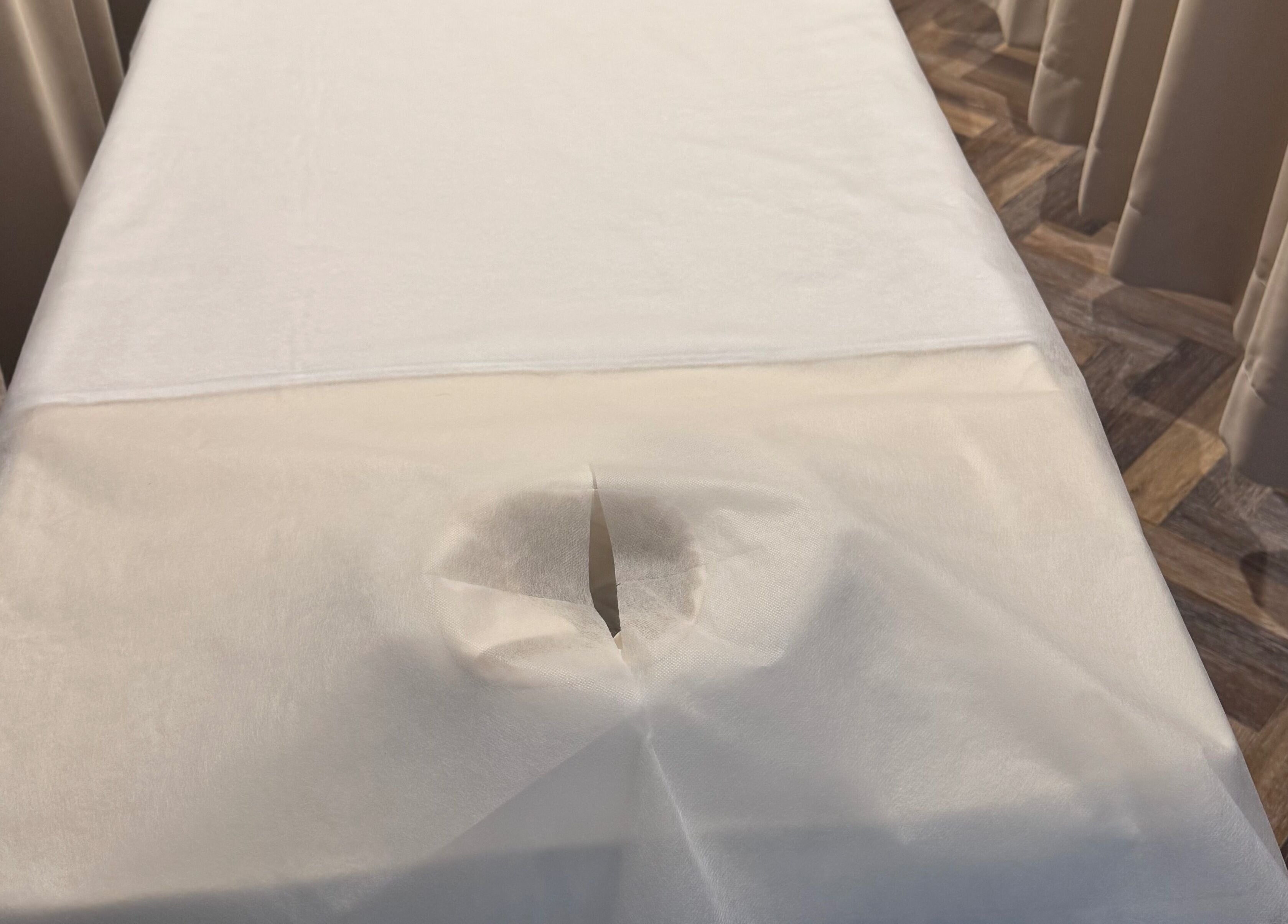 Crisp white massage table at Zenova Massage, Auckland, NZ, offering a relaxing and soothing experience.