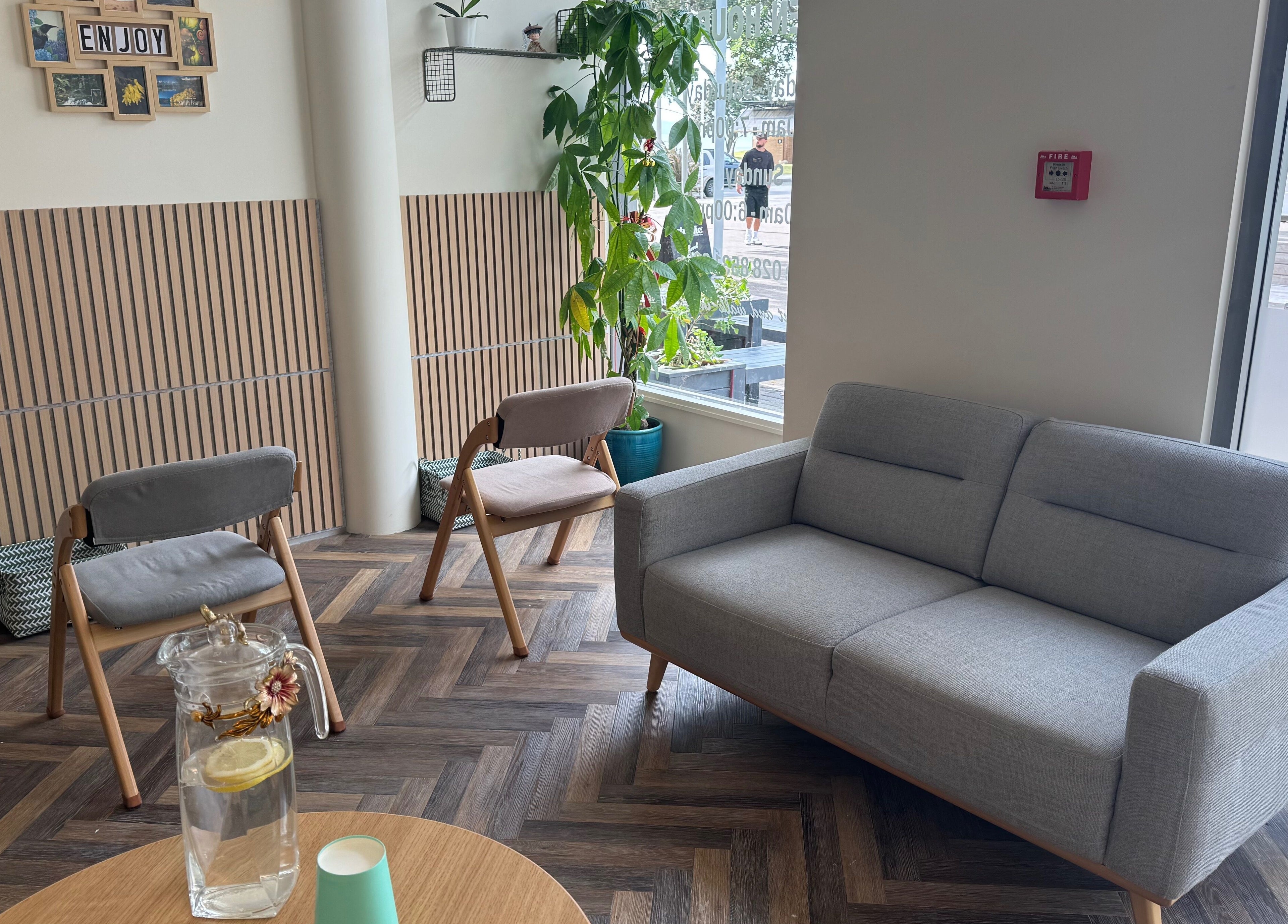 Cozy seating area at Zenova Massage, Auckland, NZ with modern chairs, plants, and natural light.